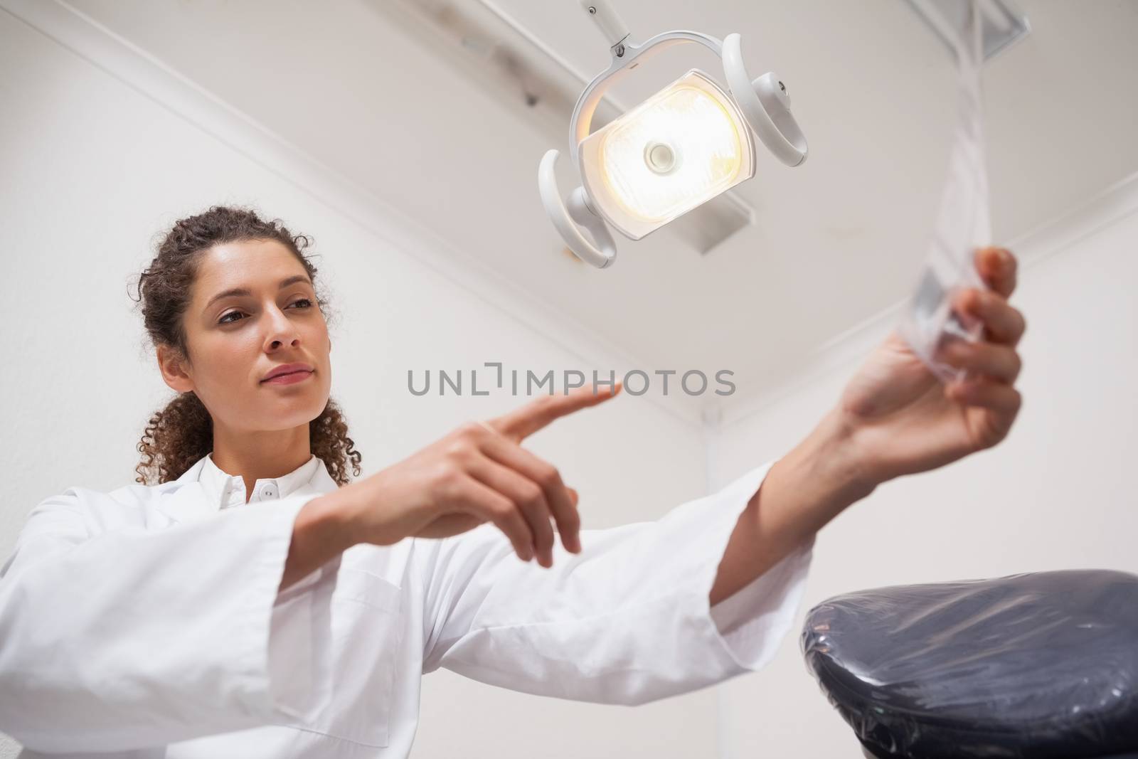 Dentist examining xrays and pointing to them at the dental clinic