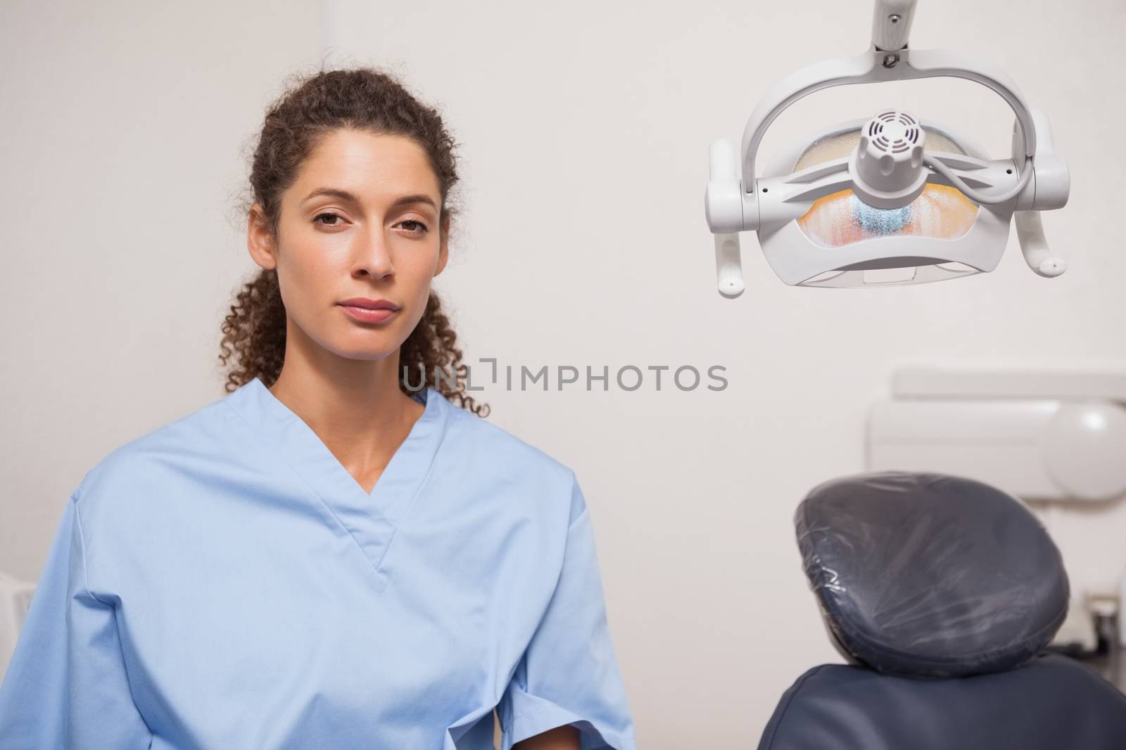 Dentist in blue scrubs looking at camera at the dental clinic