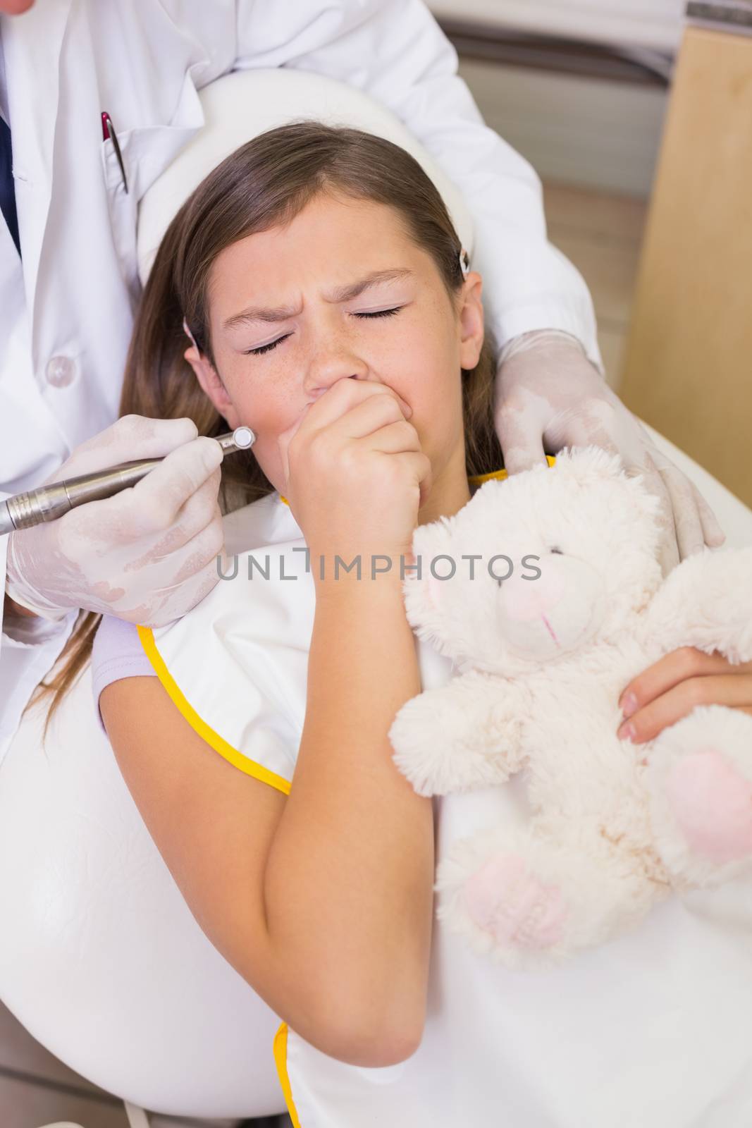 Pediatric dentist trying to see coughing patients teeth at the dental clinic