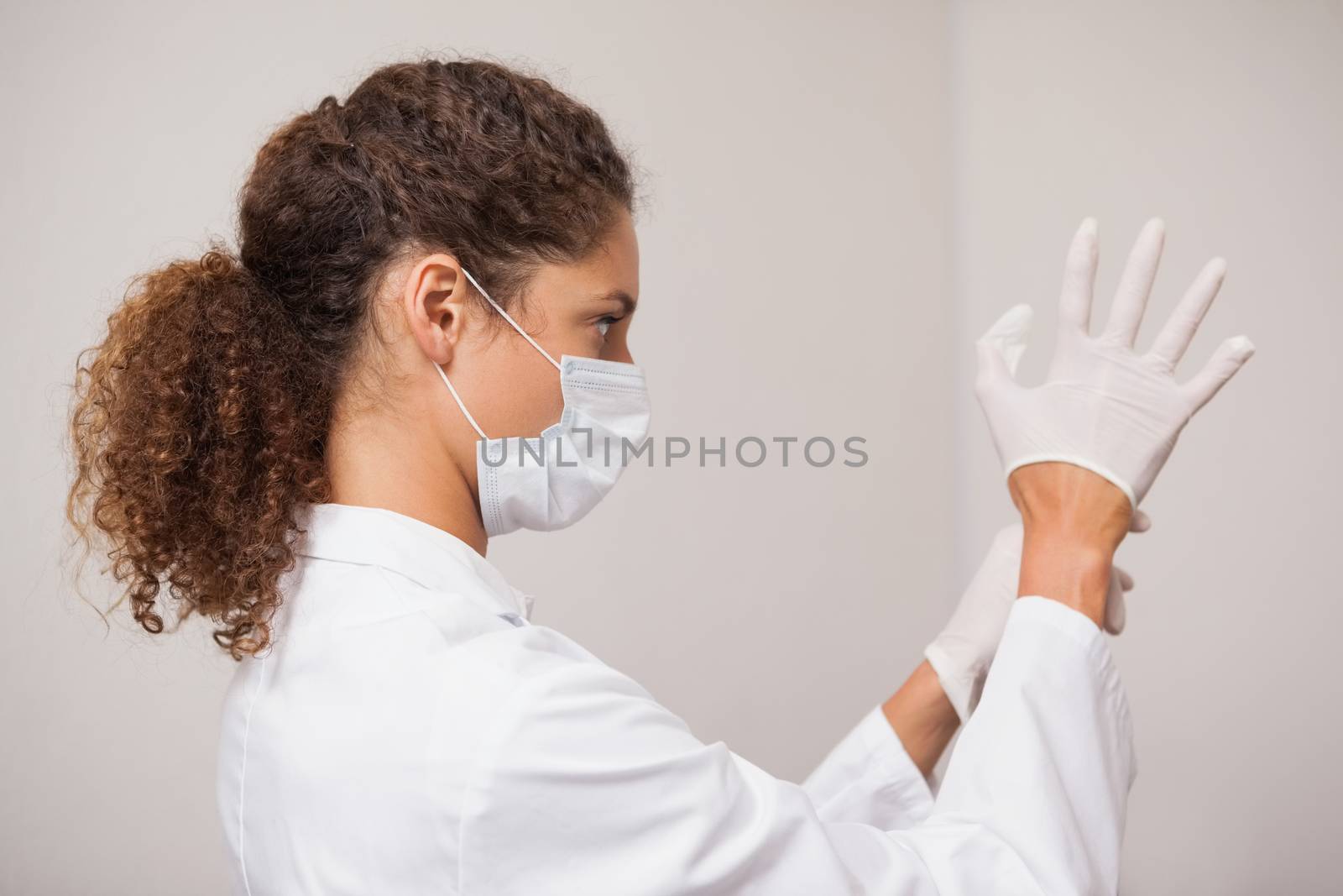 Dentist putting on surgical gloves by Wavebreakmedia