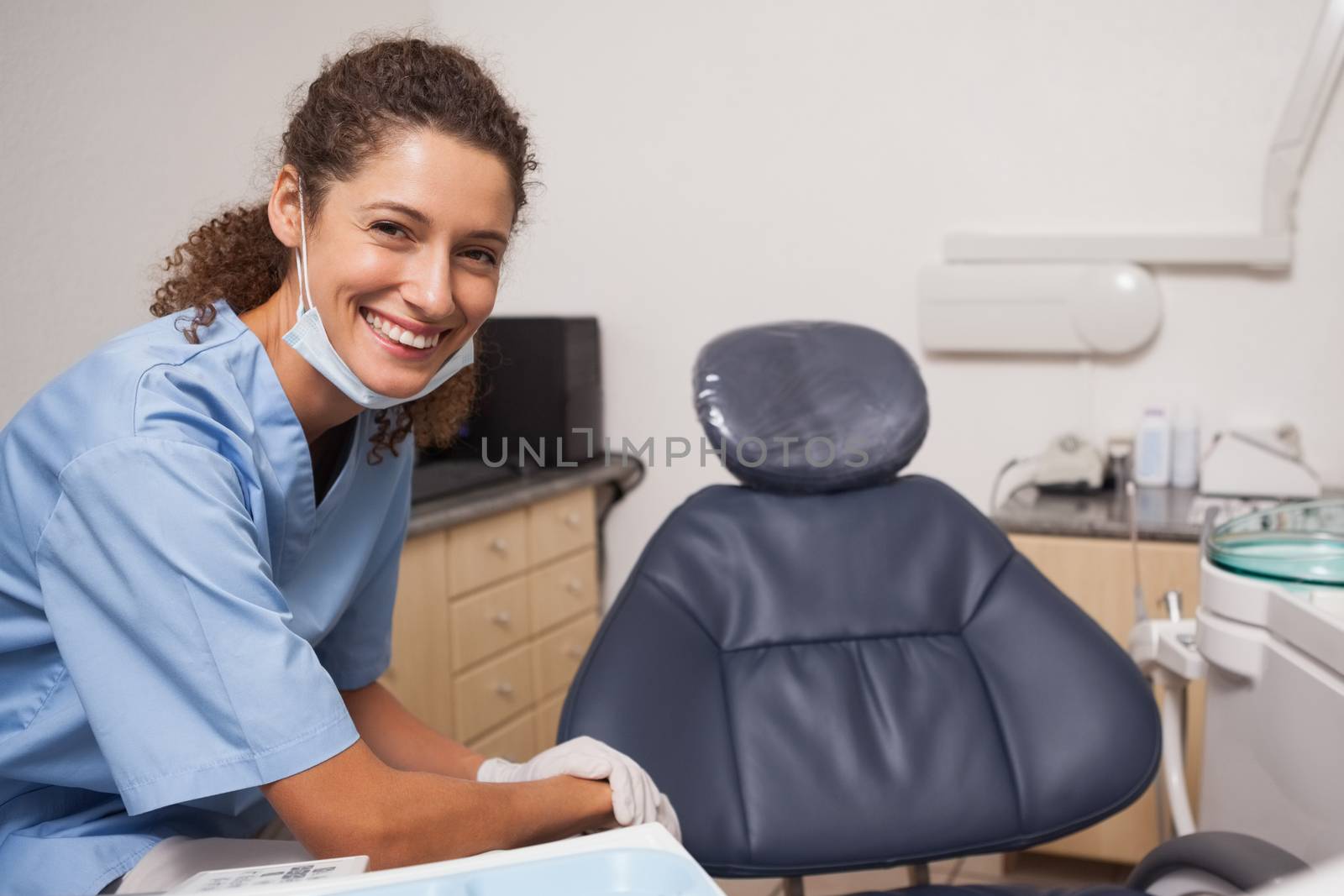 Dentist in surgical mask smiling at camera at the dental clinic