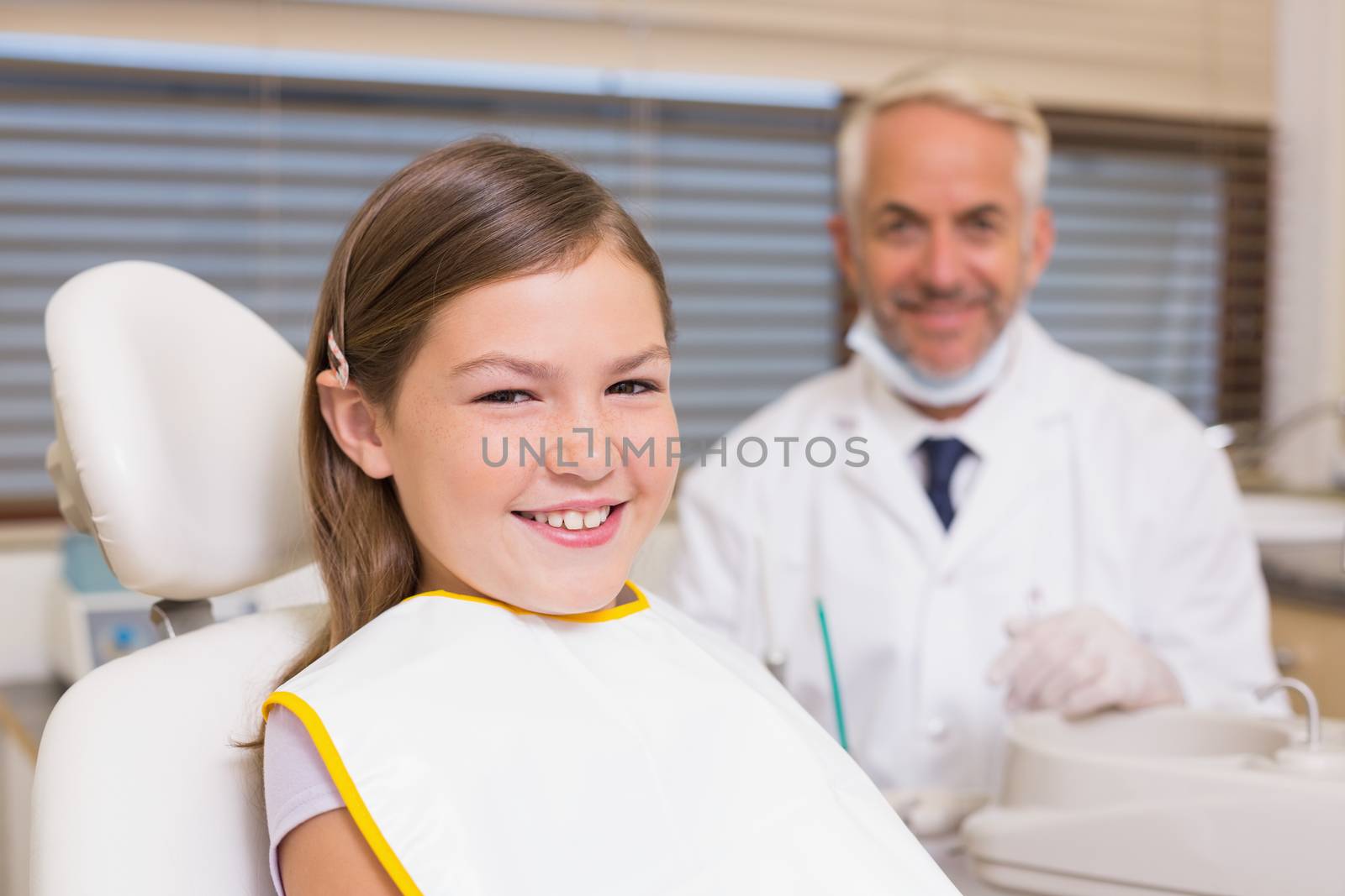 Pediatric dentist and little girl smiling at camera by Wavebreakmedia