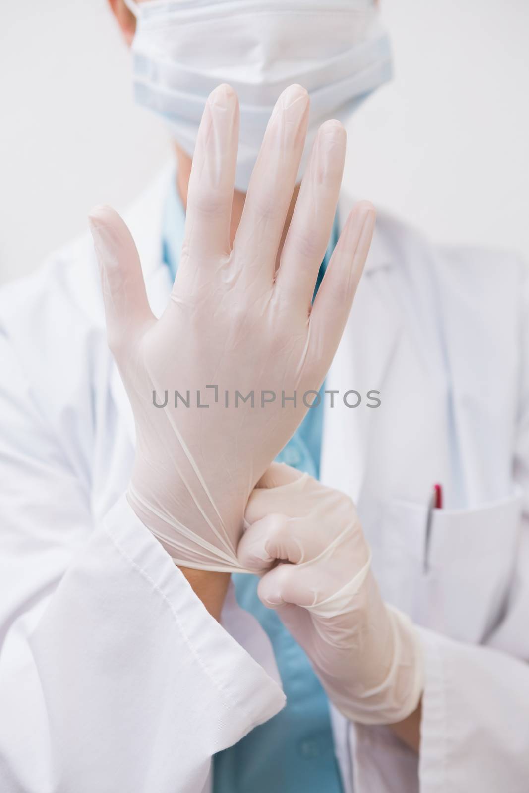 Dentist pulling on surgical gloves by Wavebreakmedia