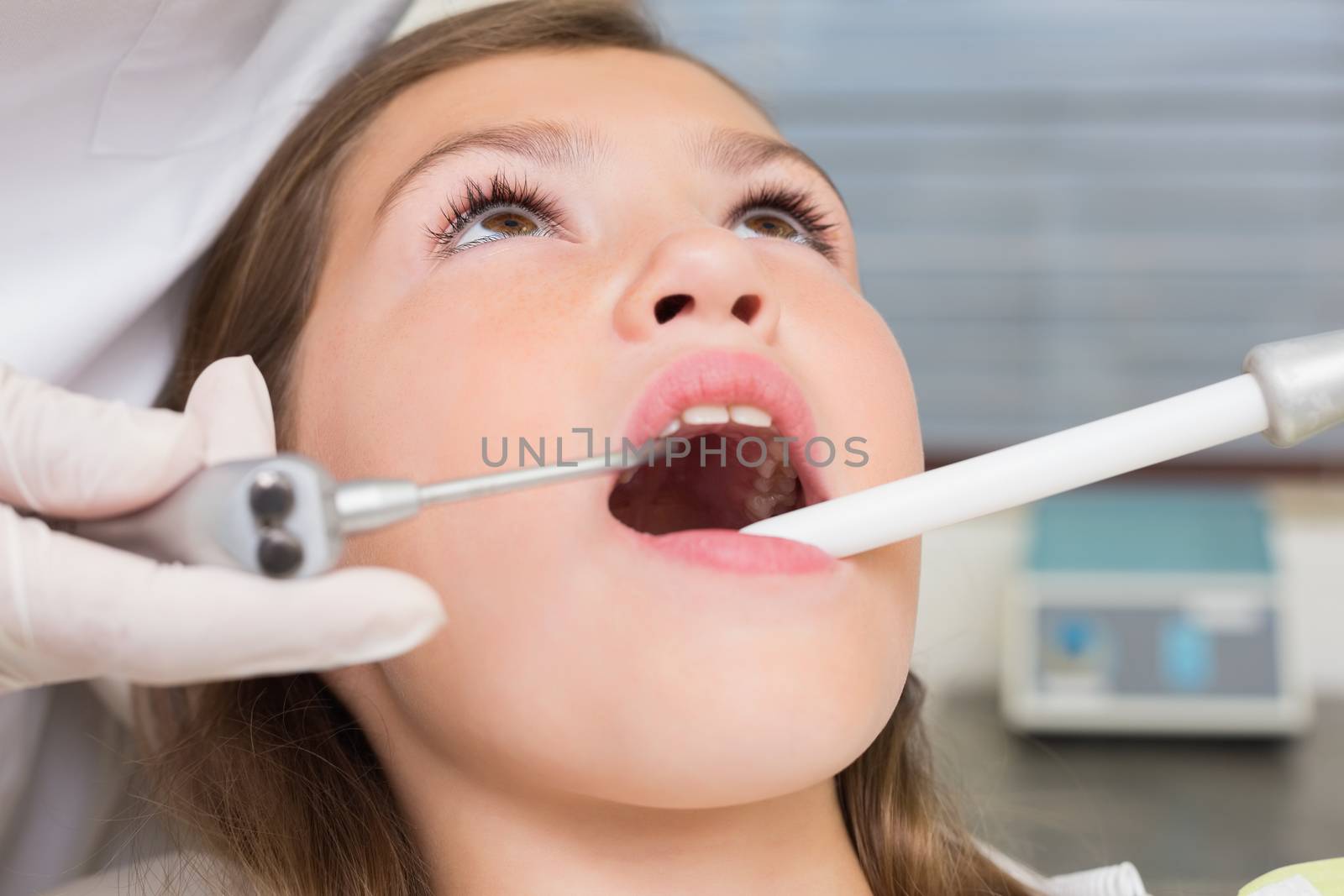Pediatric dentist examining a patients teeth in the dentists chair by Wavebreakmedia