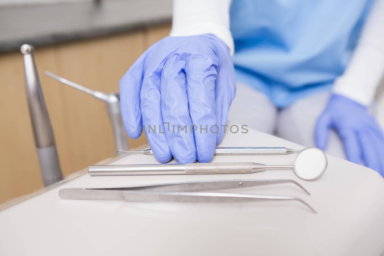 Dentist picking up dental tool at the dental clinic