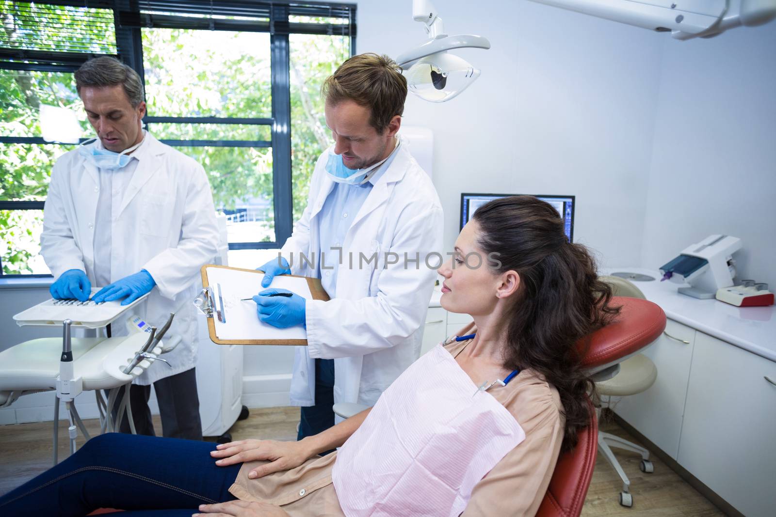 Dentist interacting with female patient at dental clinic