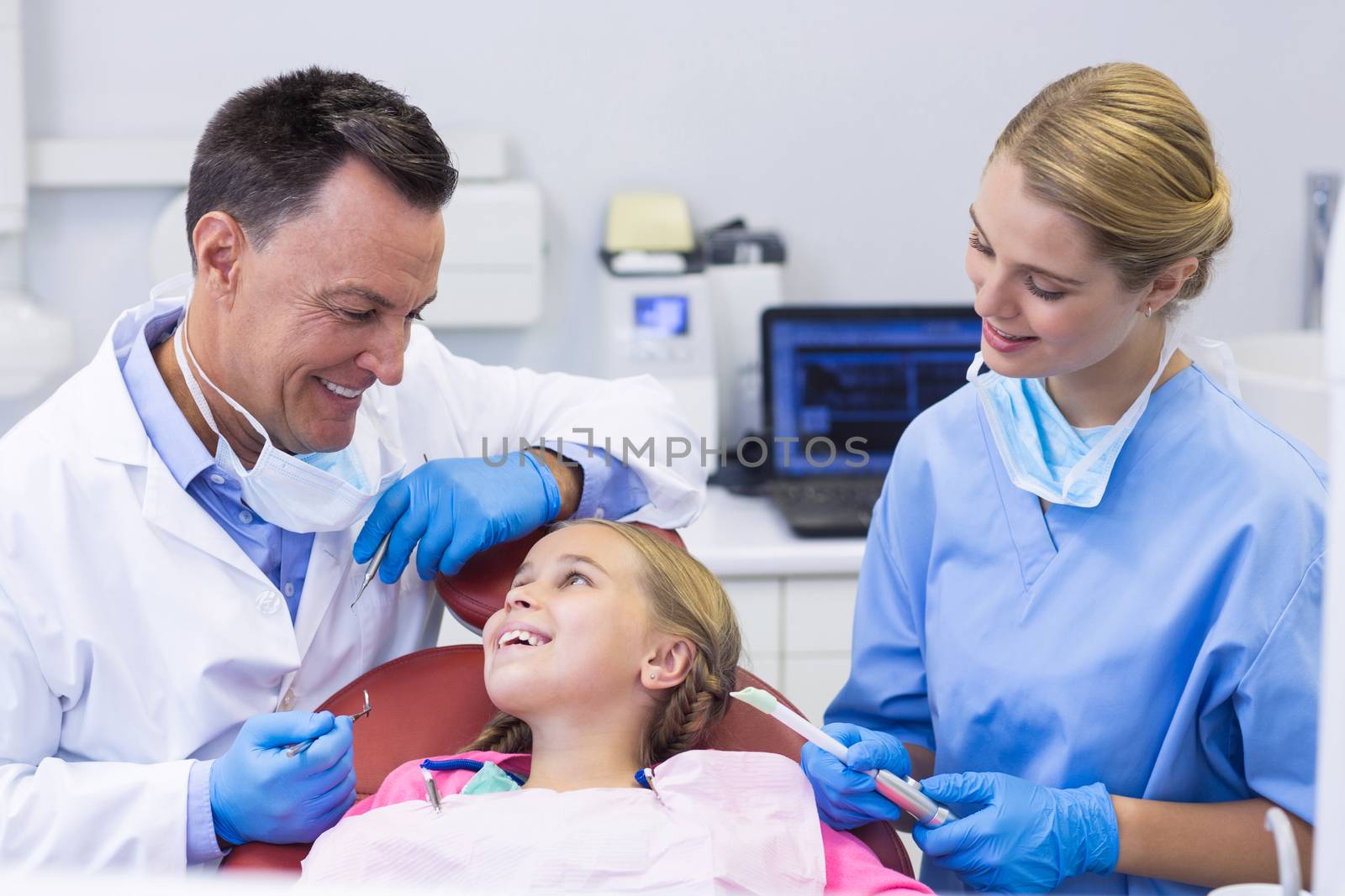 Dentist and nurse interacting with a young patient by Wavebreakmedia