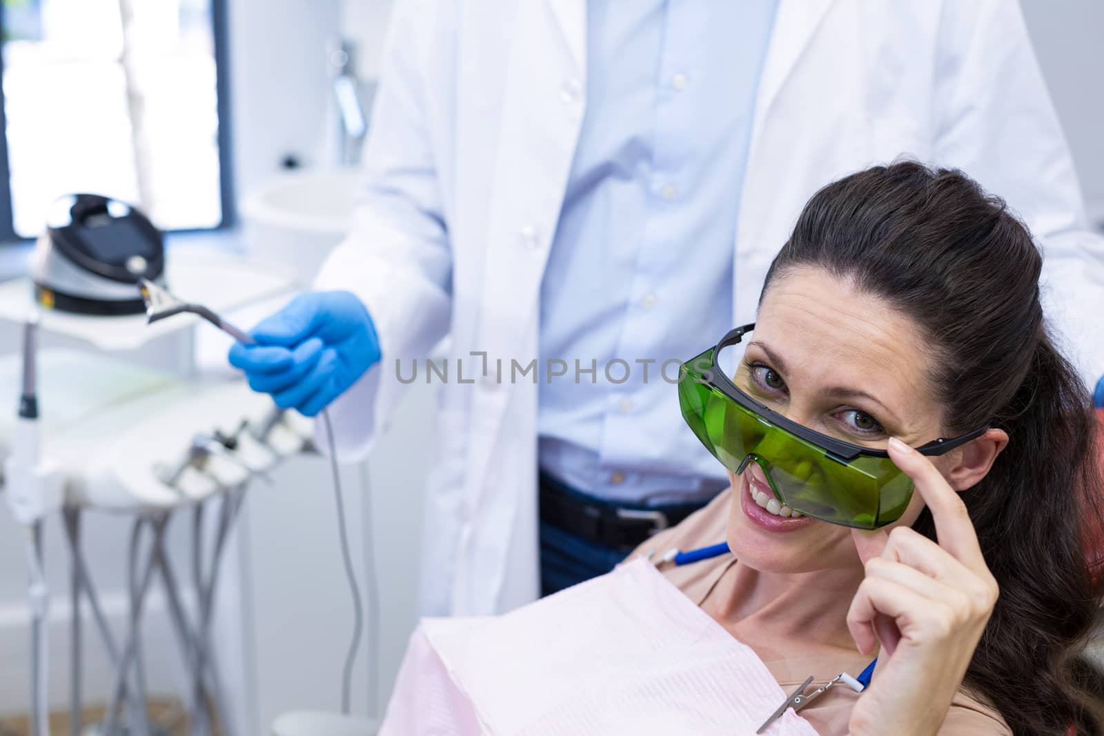 Portrait of smiling female patient sitting on dentist chair at dental clinic