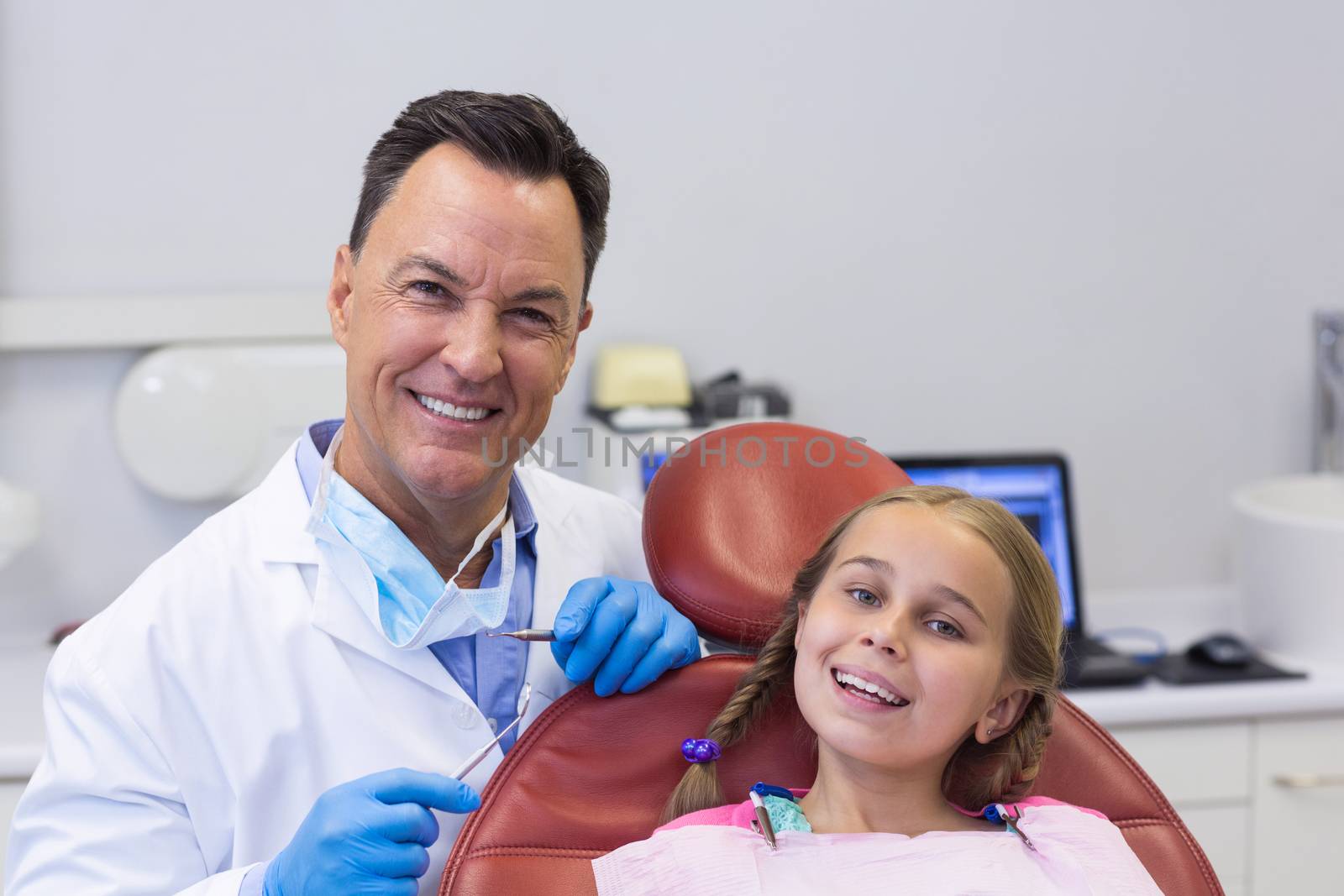 Portrait of dentist interacting with young patient at dental clinic