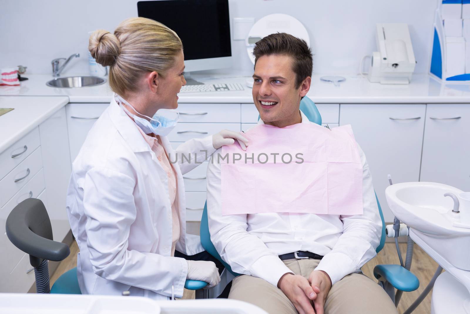 Patient looking at dentist at medical clinic by Wavebreakmedia