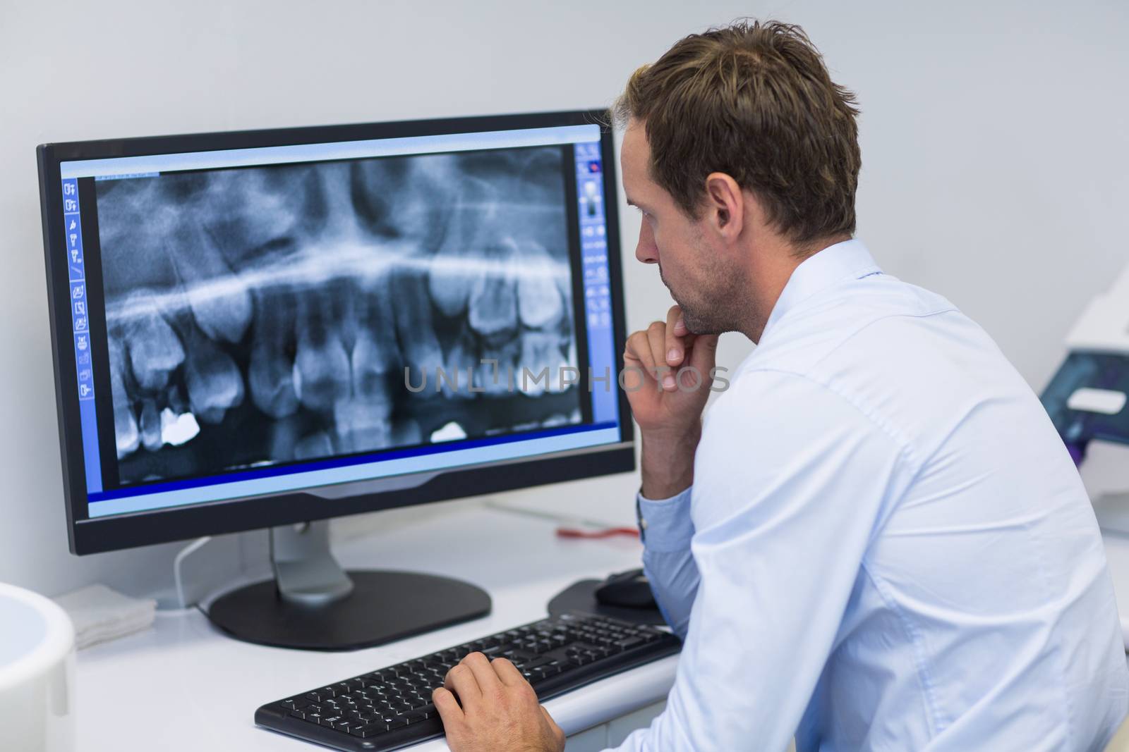 Dentist examining an x-ray on computer in dental clinic by Wavebreakmedia