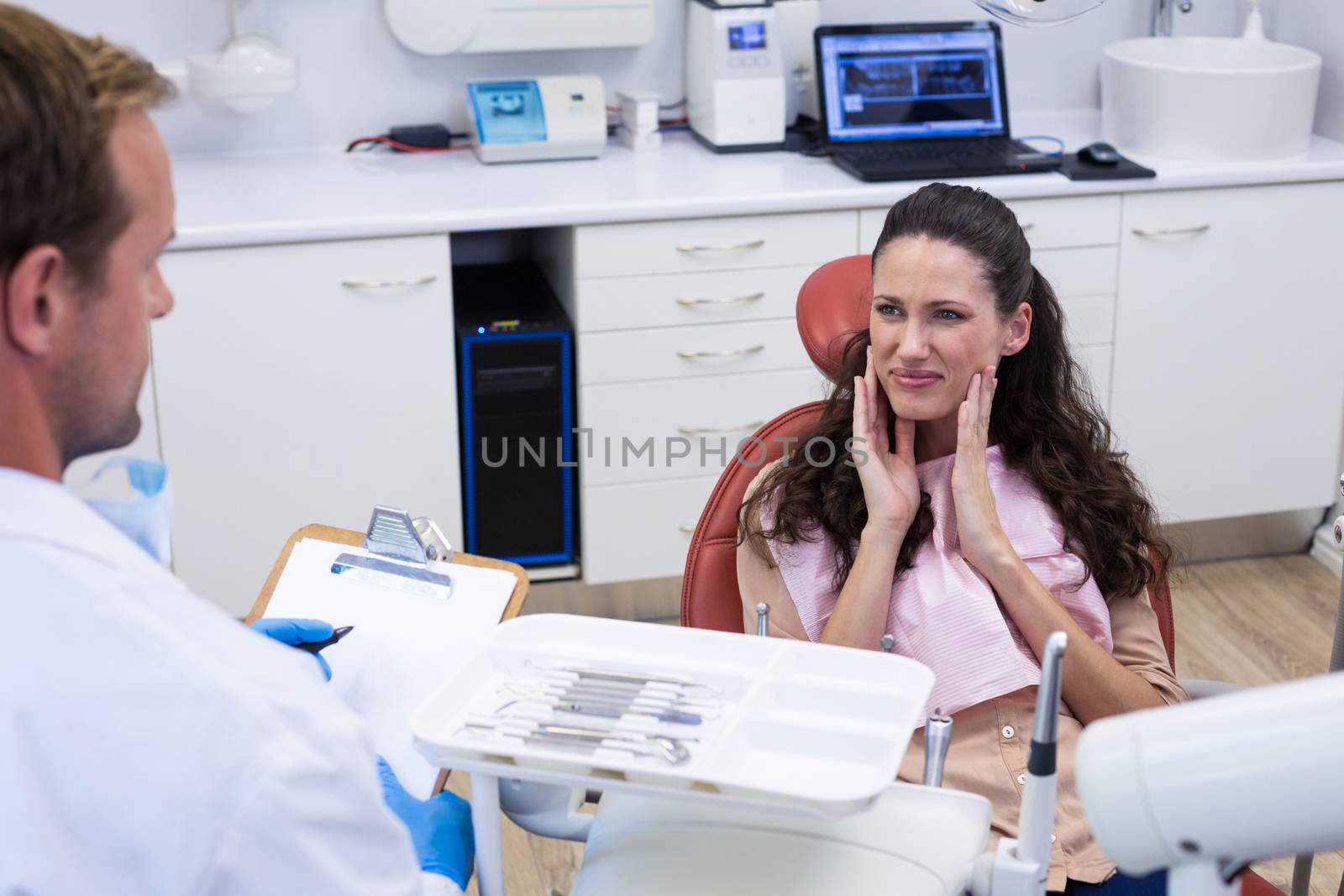 Dentist talking to female patient in dental clinic