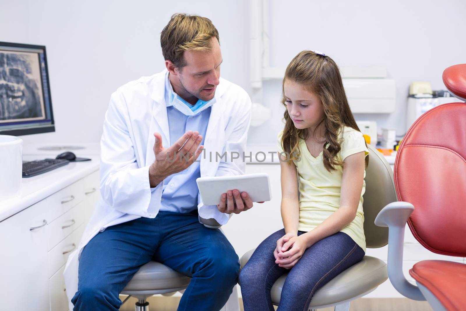 Dentist interacting with young patient in dental clinic