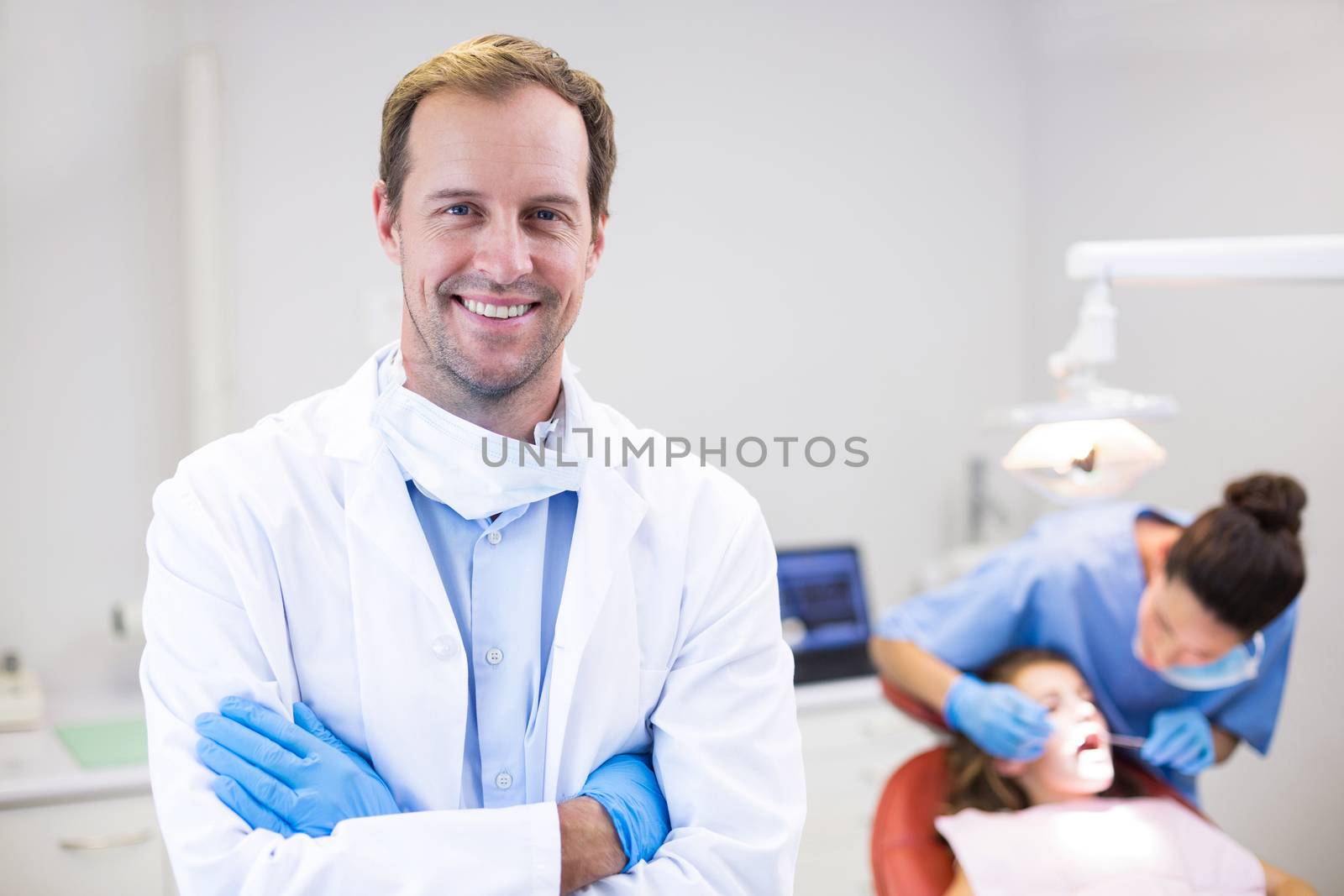 Dentist standing with arms crossed in clinic by Wavebreakmedia