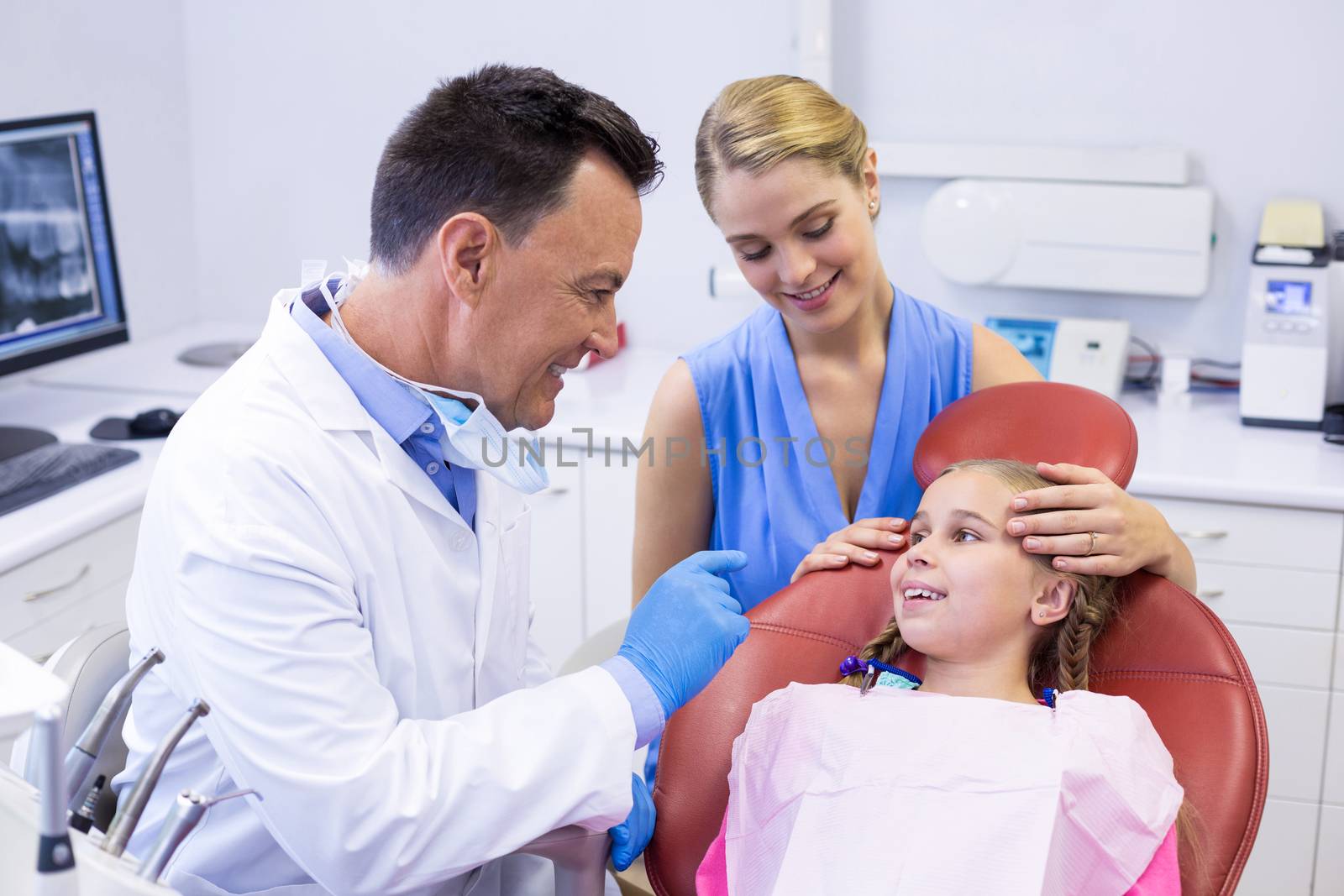 Dentist interacting with young patient by Wavebreakmedia
