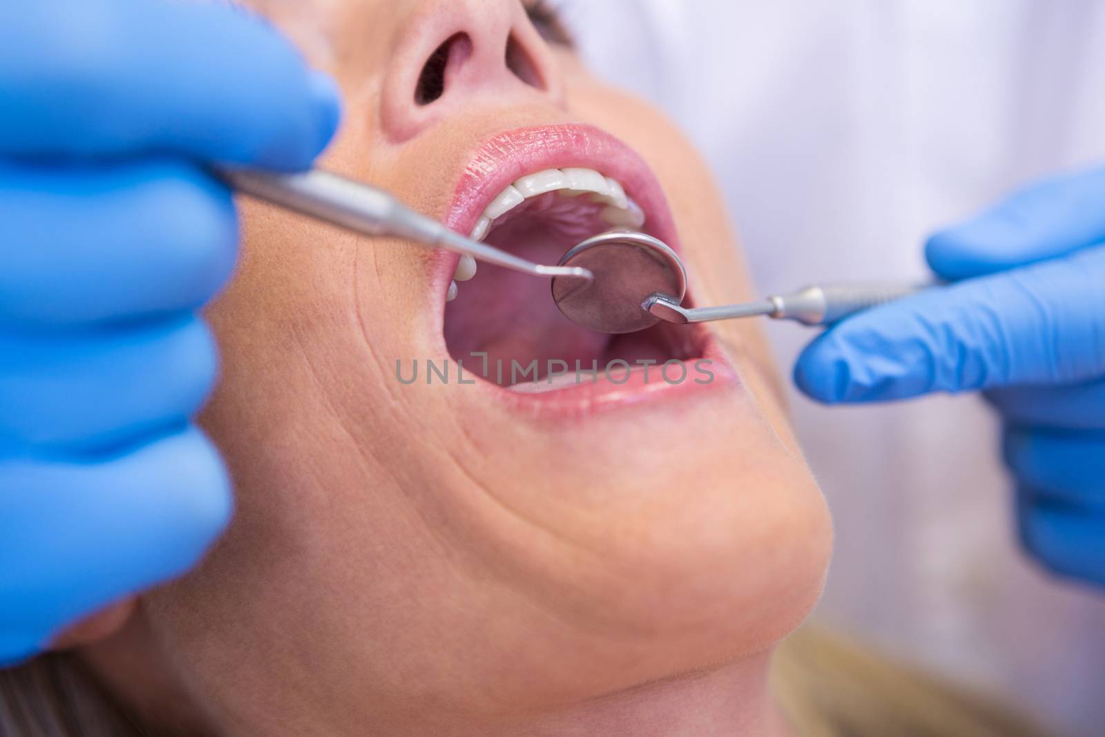 Dentist examining patient at medical clinic by Wavebreakmedia