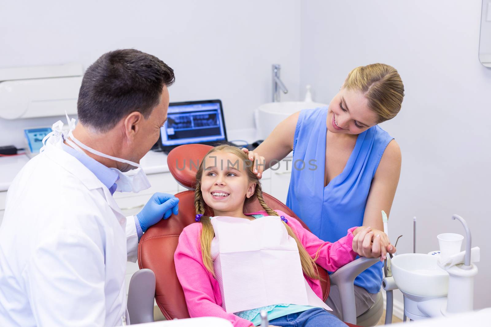 Dentist interacting with young patient by Wavebreakmedia