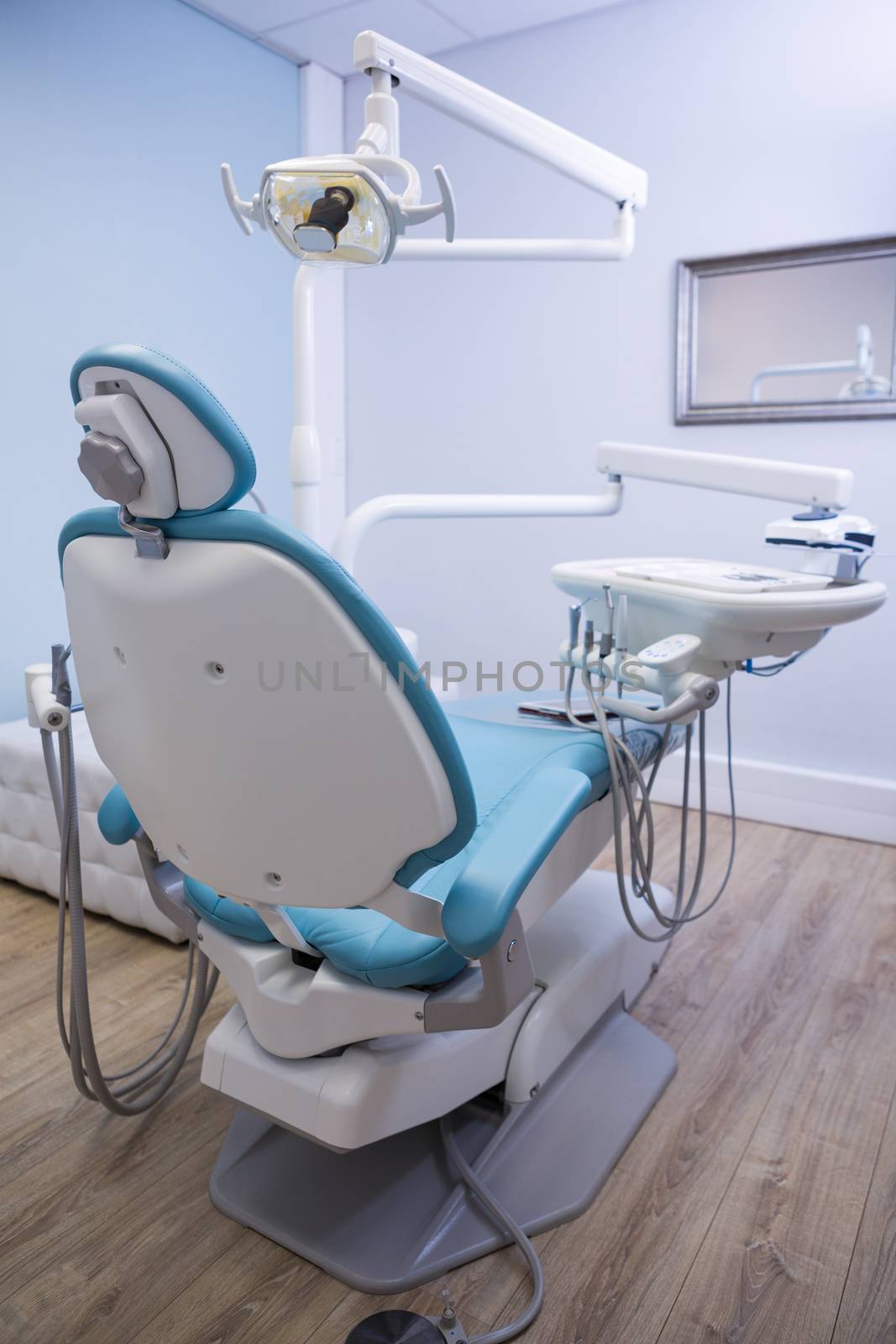 Dentist chair with medical equipment in clinic by Wavebreakmedia