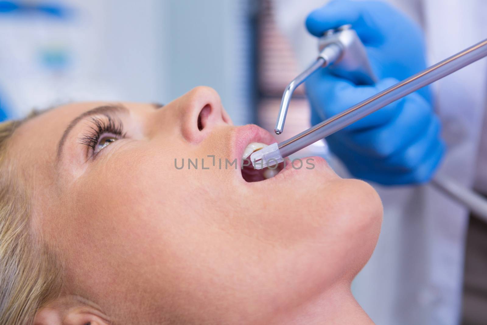 Extreme close up of dentist examining woman by Wavebreakmedia