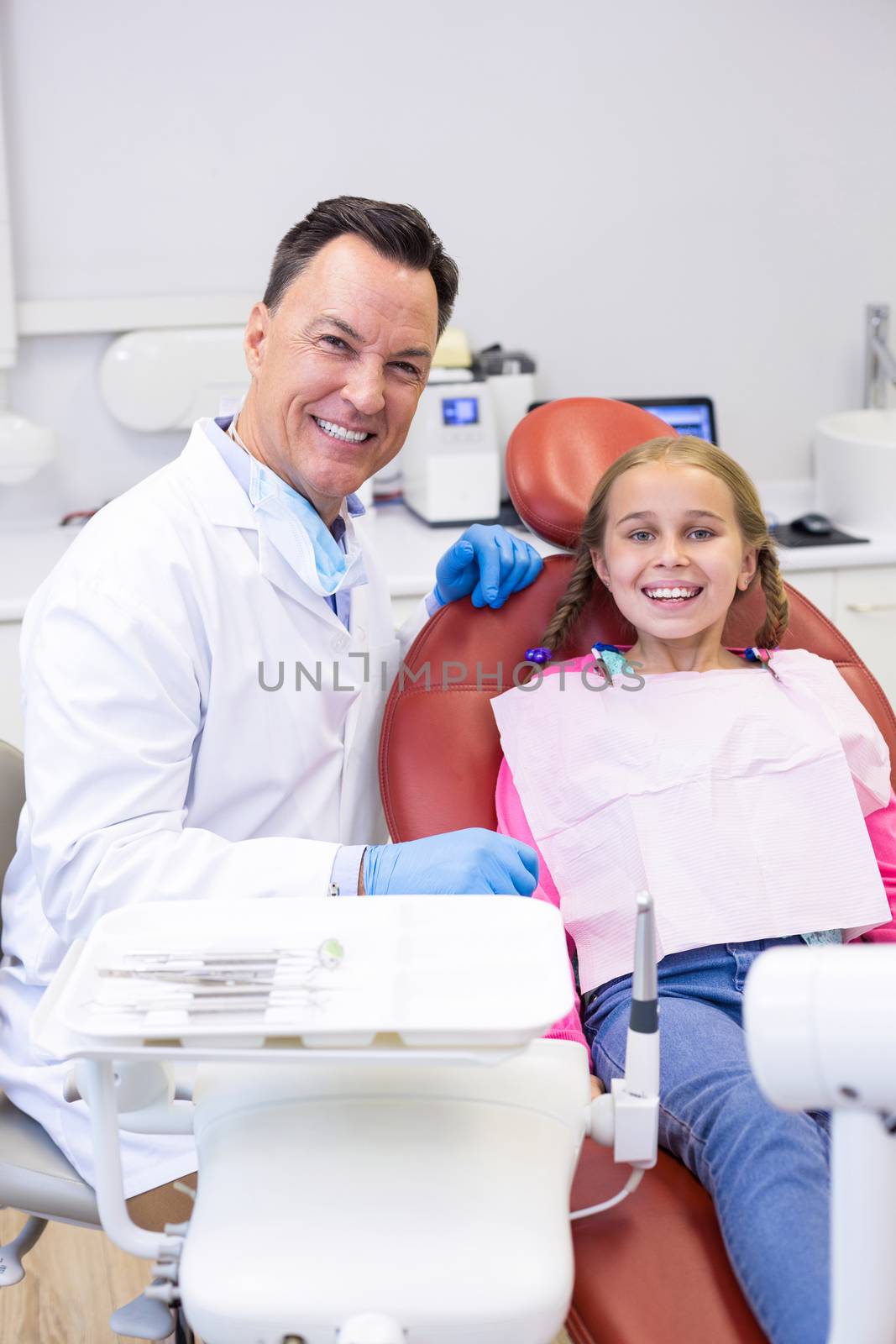 Portrait of dentist interacting with young patient at dental clinic