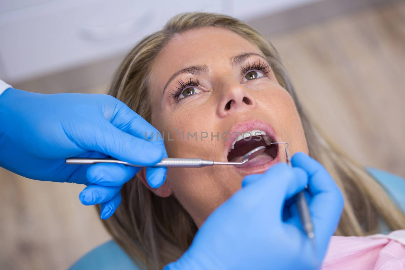 Dentist examining woman at hospital by Wavebreakmedia