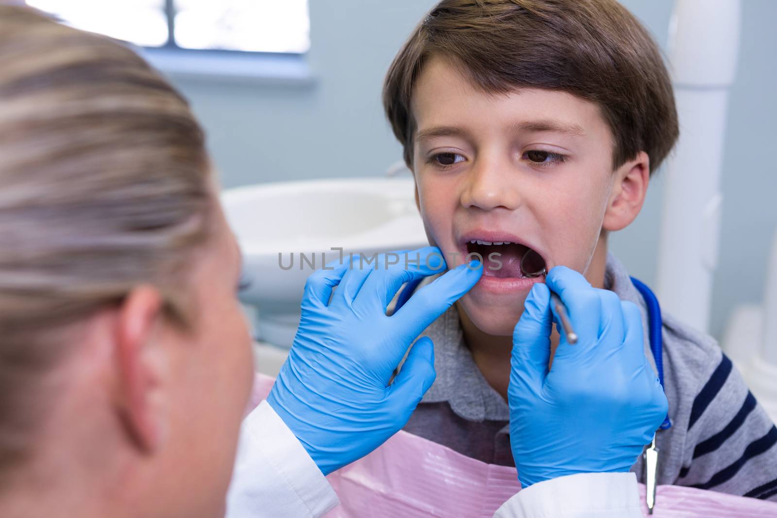 Close up of dentist examining boy at dental clinic
