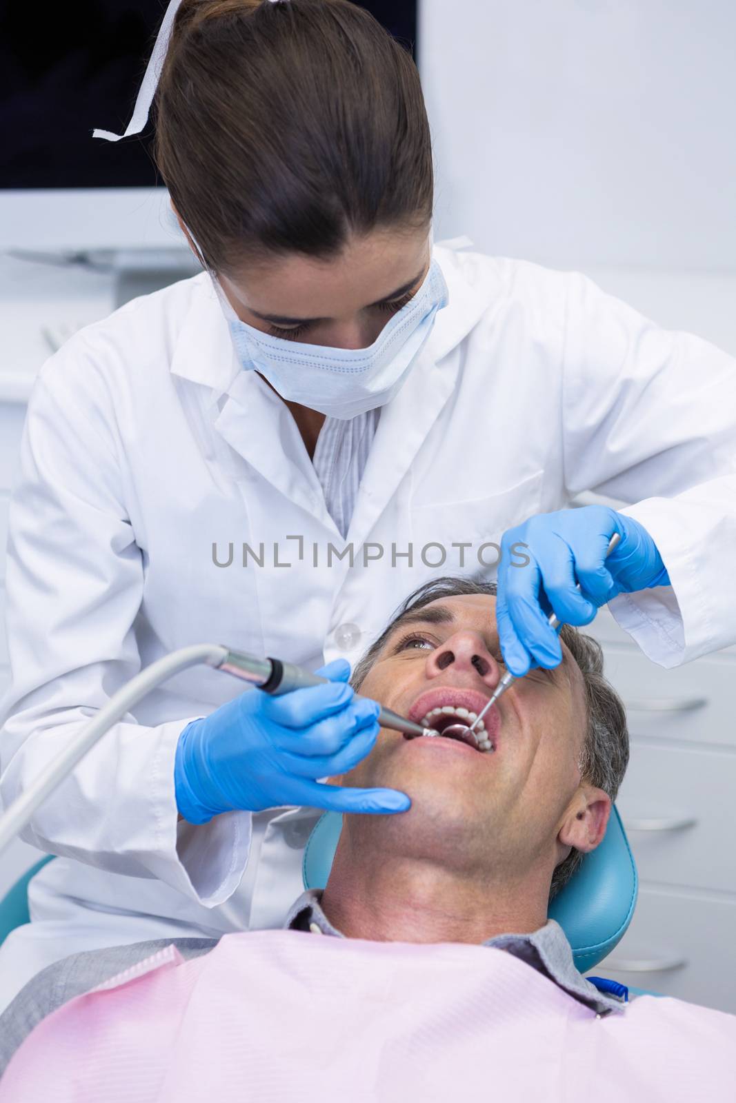 Close up of dentist examining senior man mouth at medical clinic