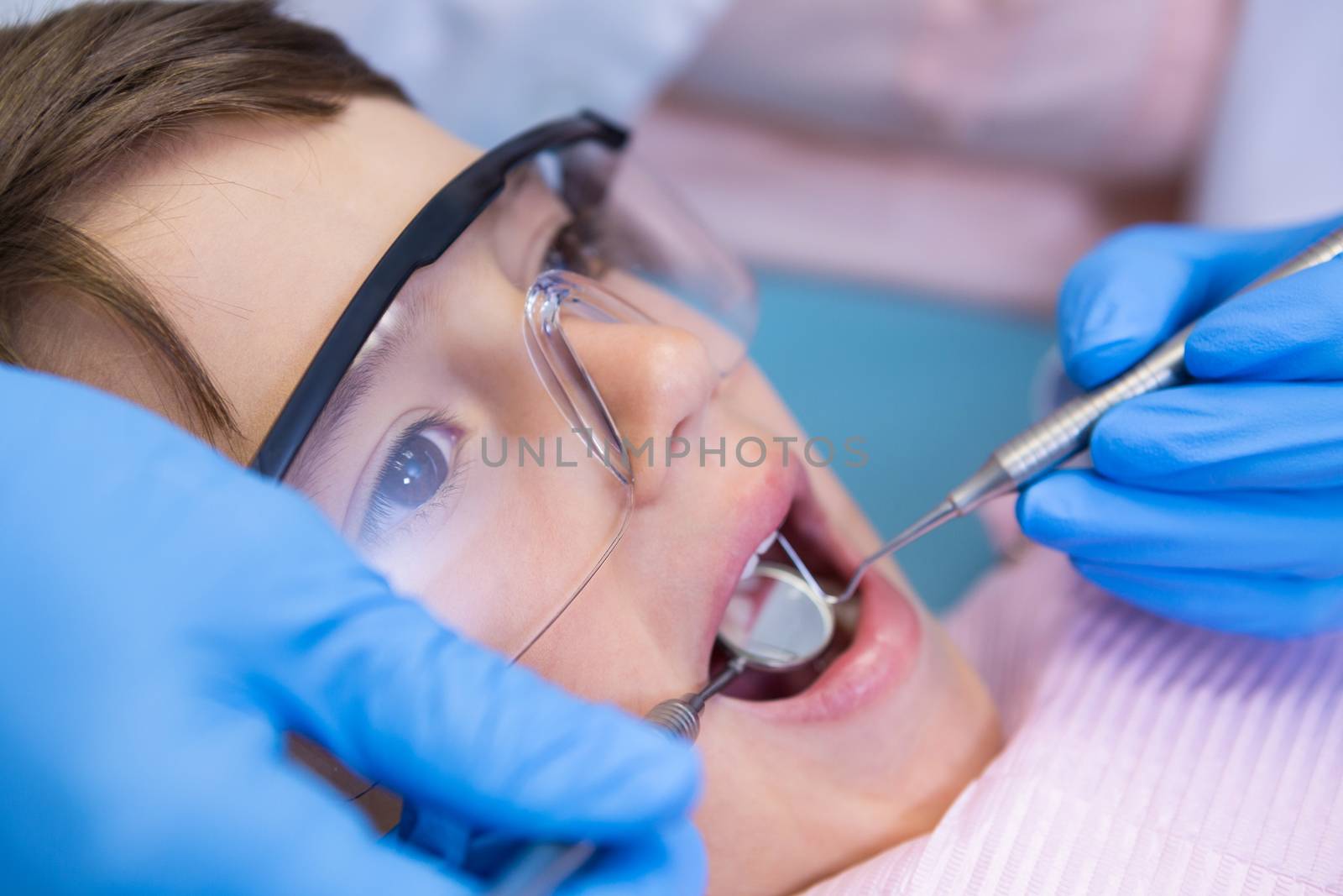 Dentist examining boy at clinic by Wavebreakmedia