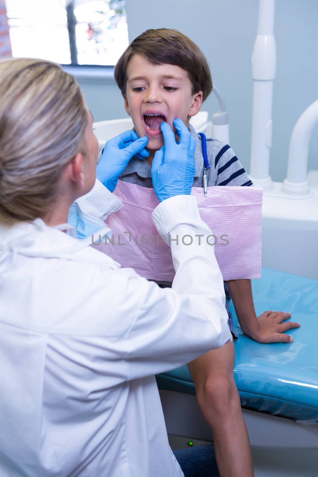 Dentist examining boy at dental clinic by Wavebreakmedia