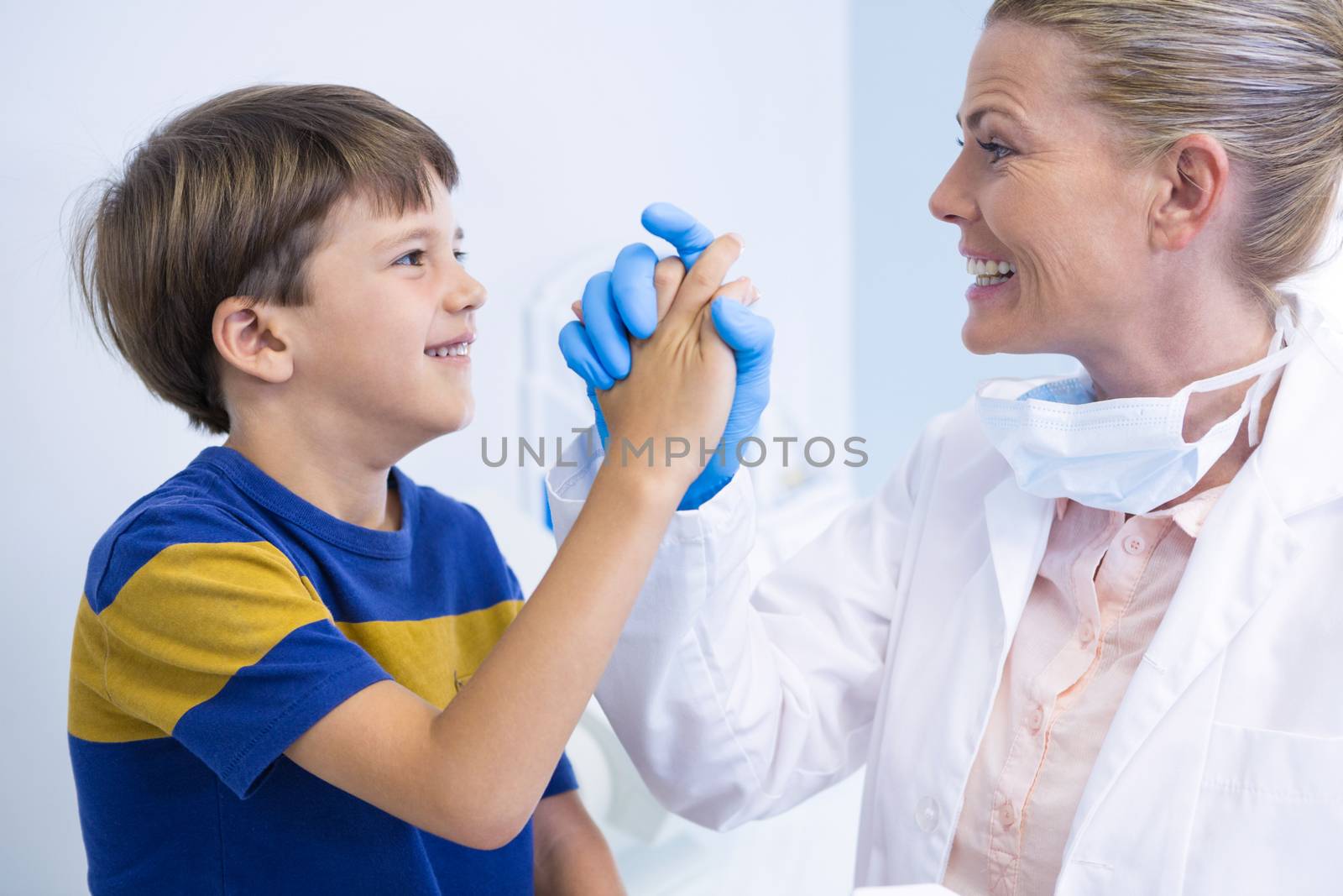 Smiling dentist playing with boy by Wavebreakmedia