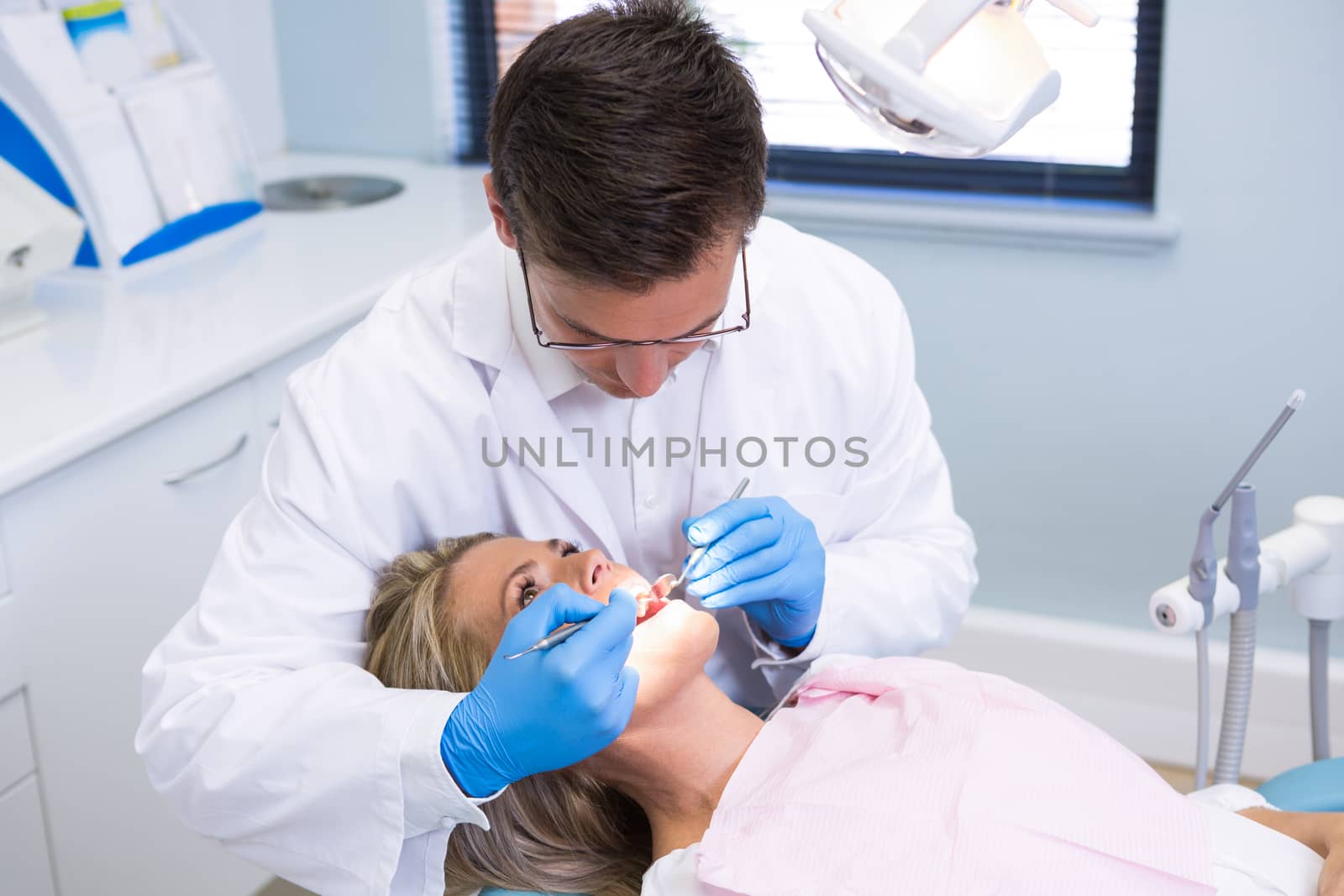 High angle view of dentist examining woman with dental equipments by Wavebreakmedia