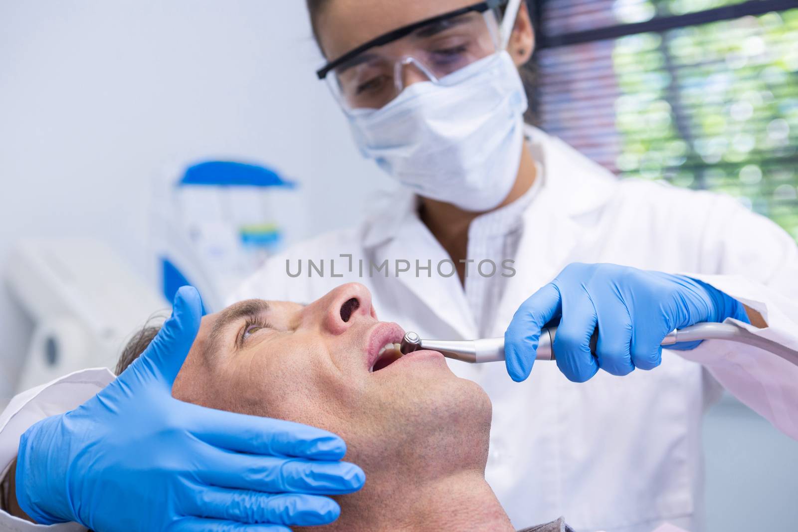 Close up of man receiving dental treatment by dentist at clinic