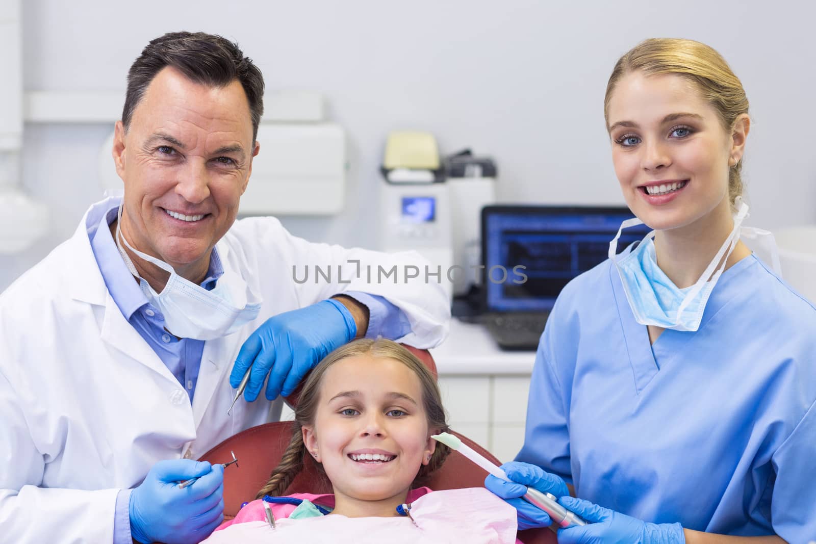 Portrait of dentist and nurse examining a young patient with tools by Wavebreakmedia