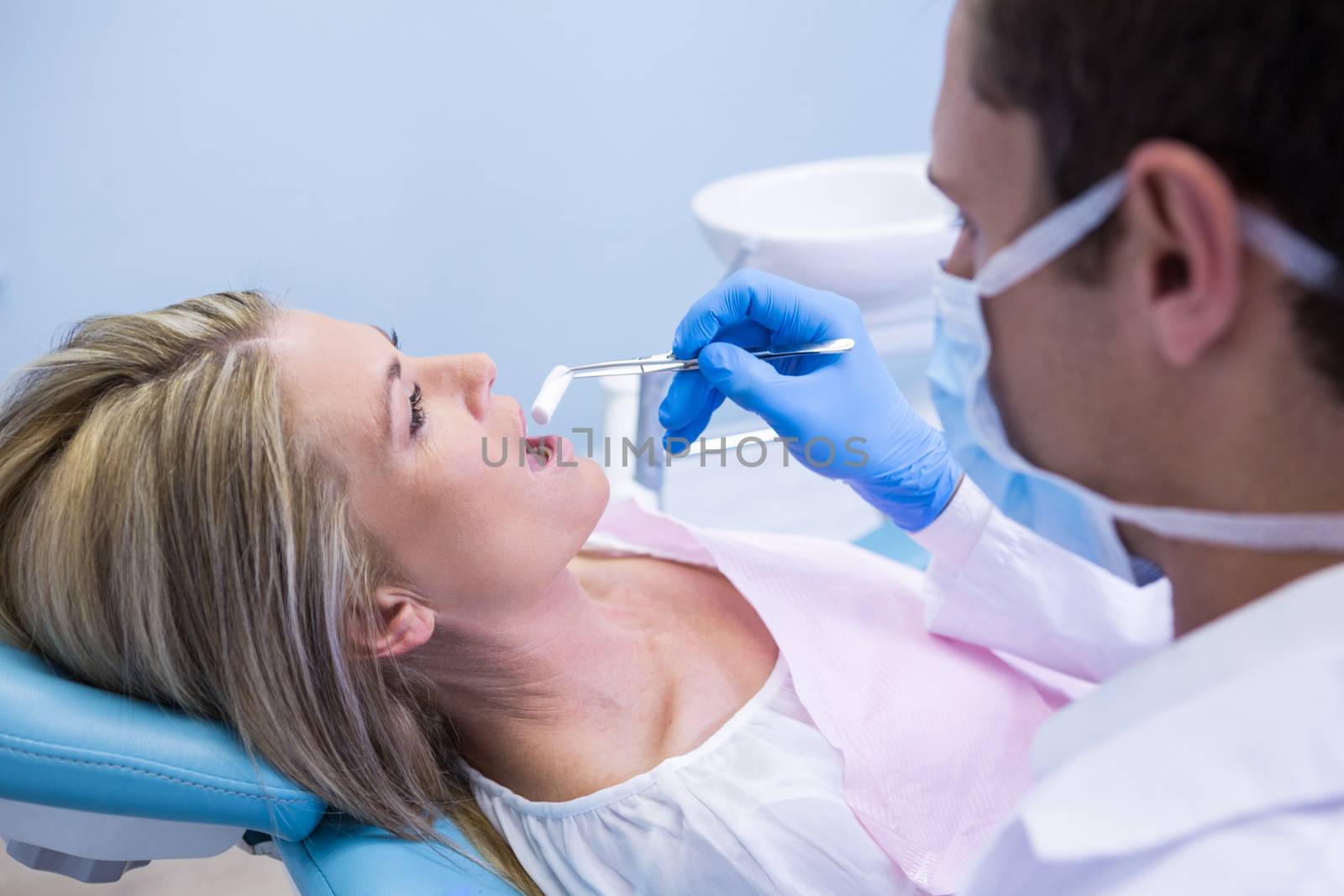 Dentist examining woman at clinic by Wavebreakmedia