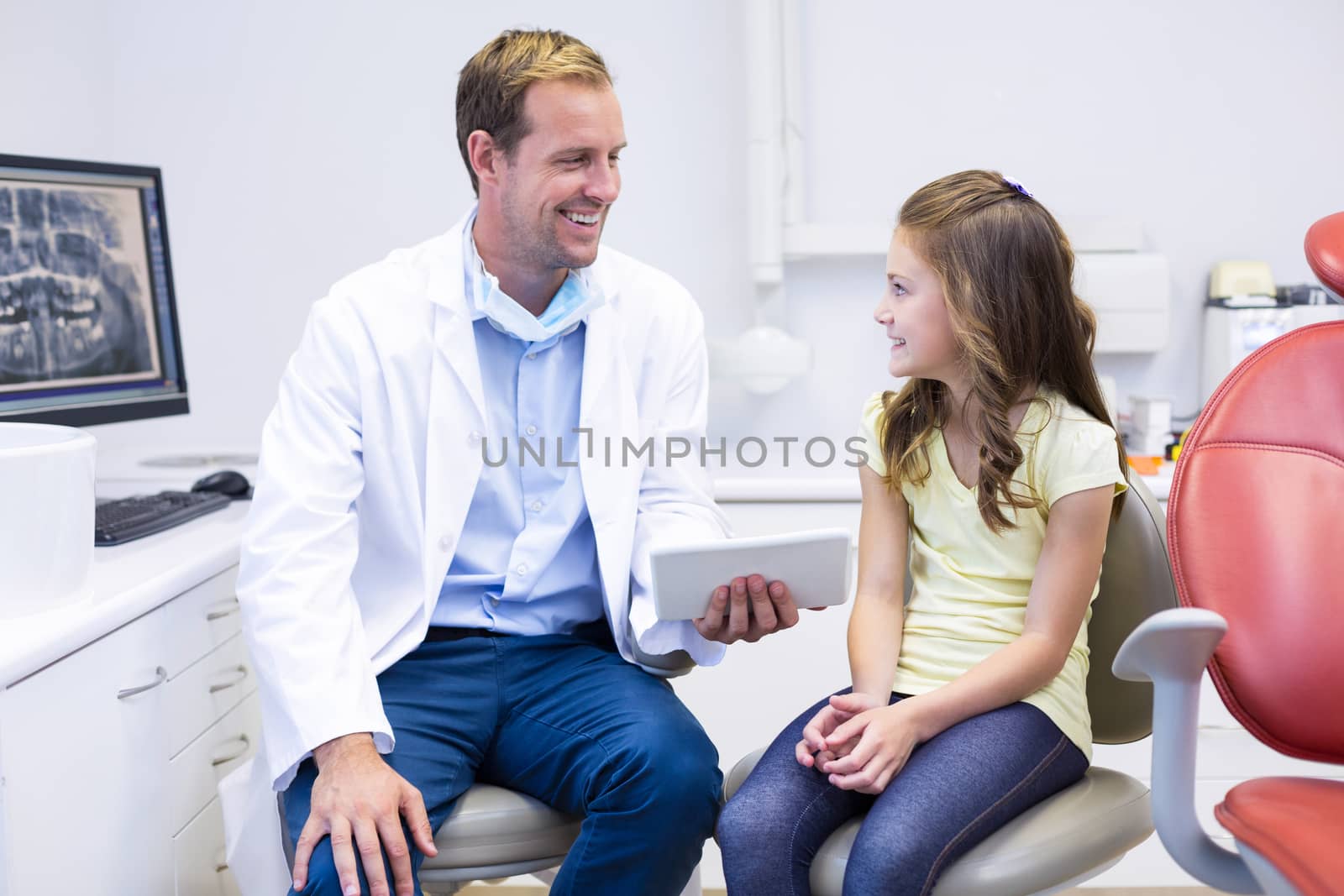 Dentist interacting with young patient in dental clinic by Wavebreakmedia