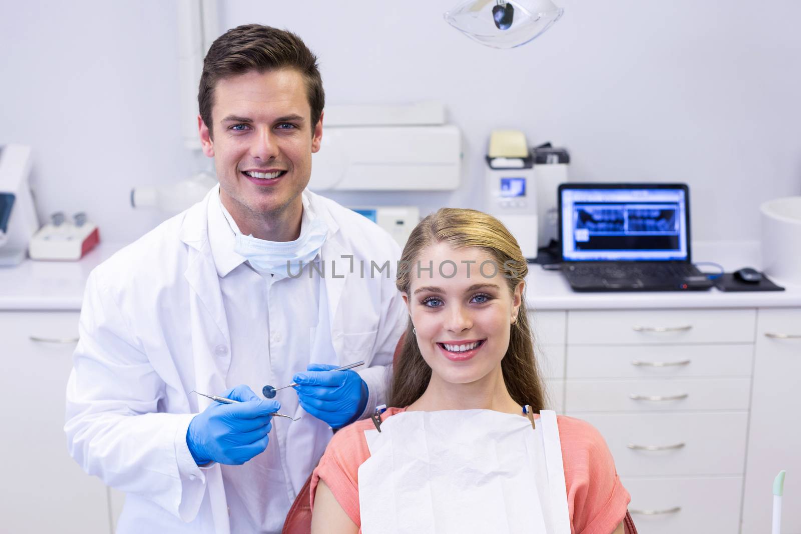 Portrait of happy dentist and female patient in clinic