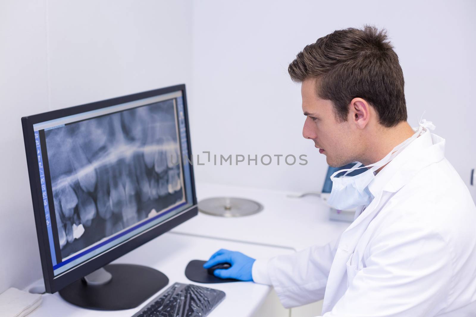 Attentive dentist examining x-ray report on computer in clinic