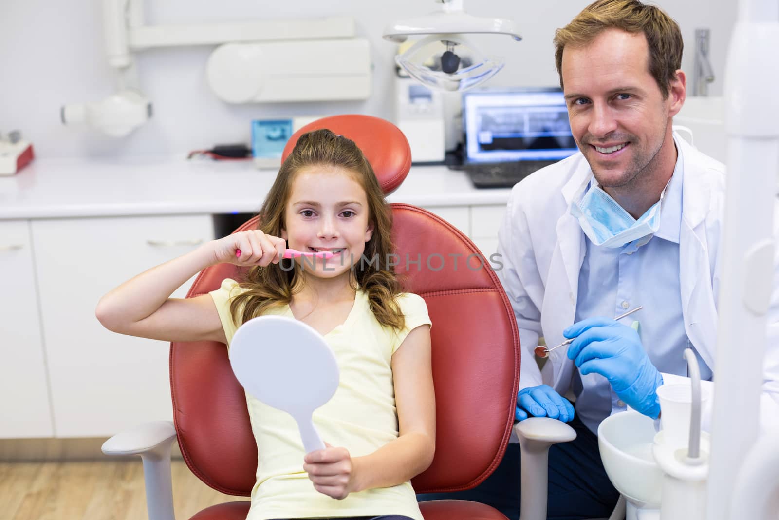 Smiling young patient with a dentist in dental clinic by Wavebreakmedia