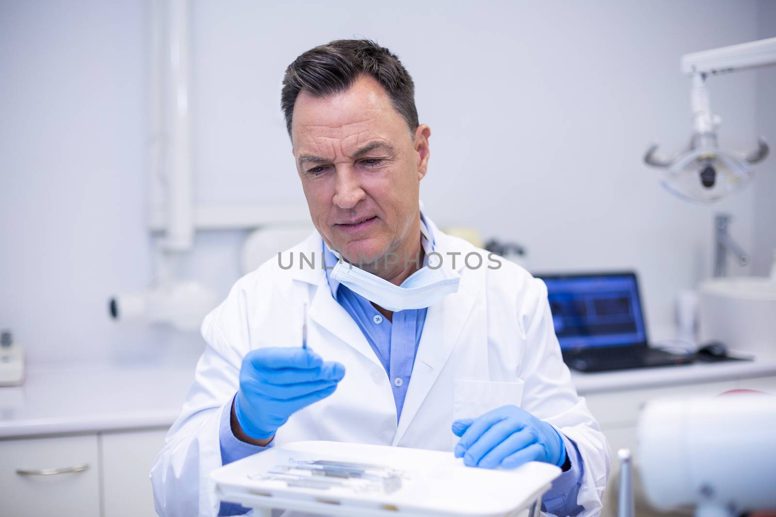 Attentive dentist checking tools in dental clinic