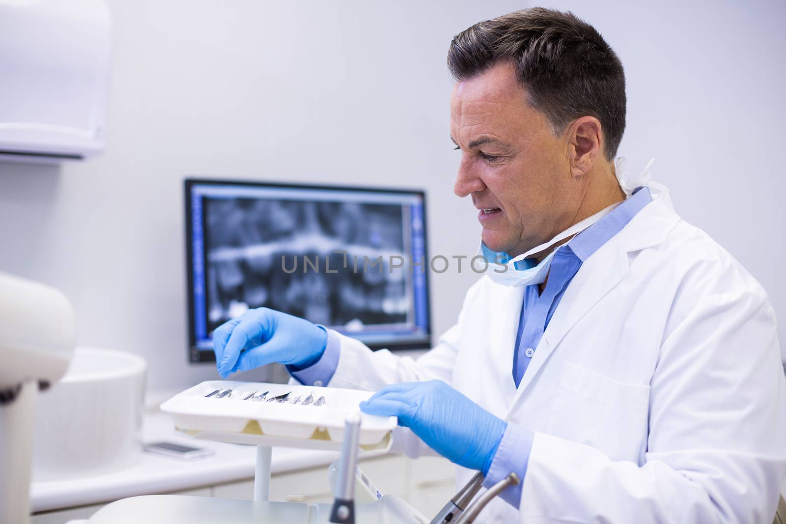 Attentive dentist checking tools in dental clinic