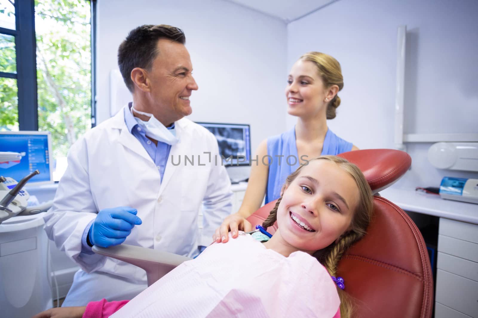 Dentist interacting with young patients mother at dental clinic