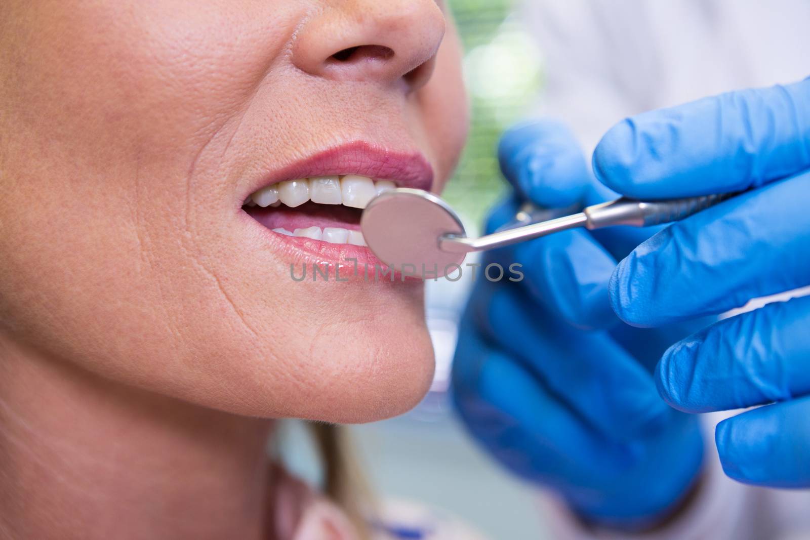 Cropped image of dentist examining woman by Wavebreakmedia