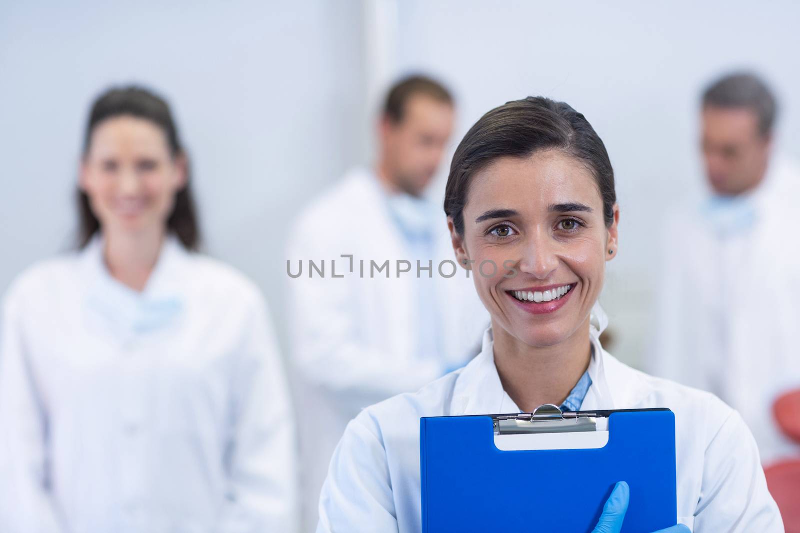 Portrait of smiling dentist standing at dental clinic