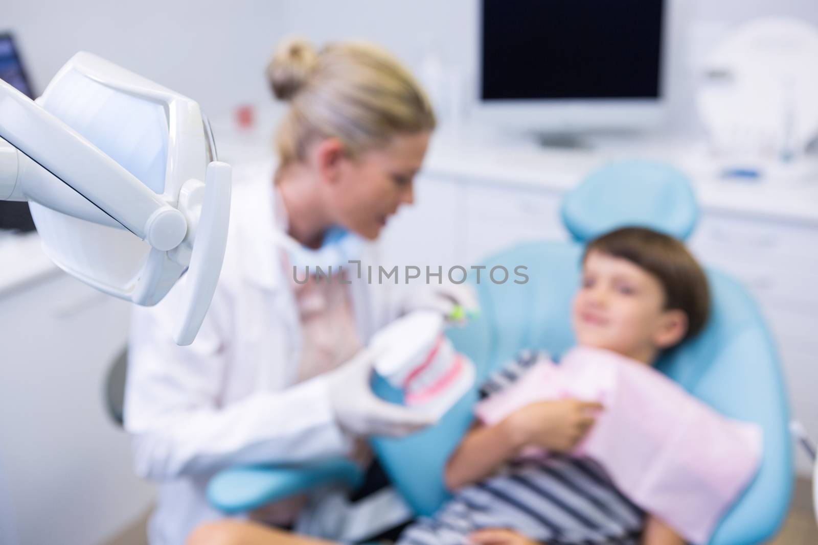 Boy receiving treatment by dentist at dental clinic