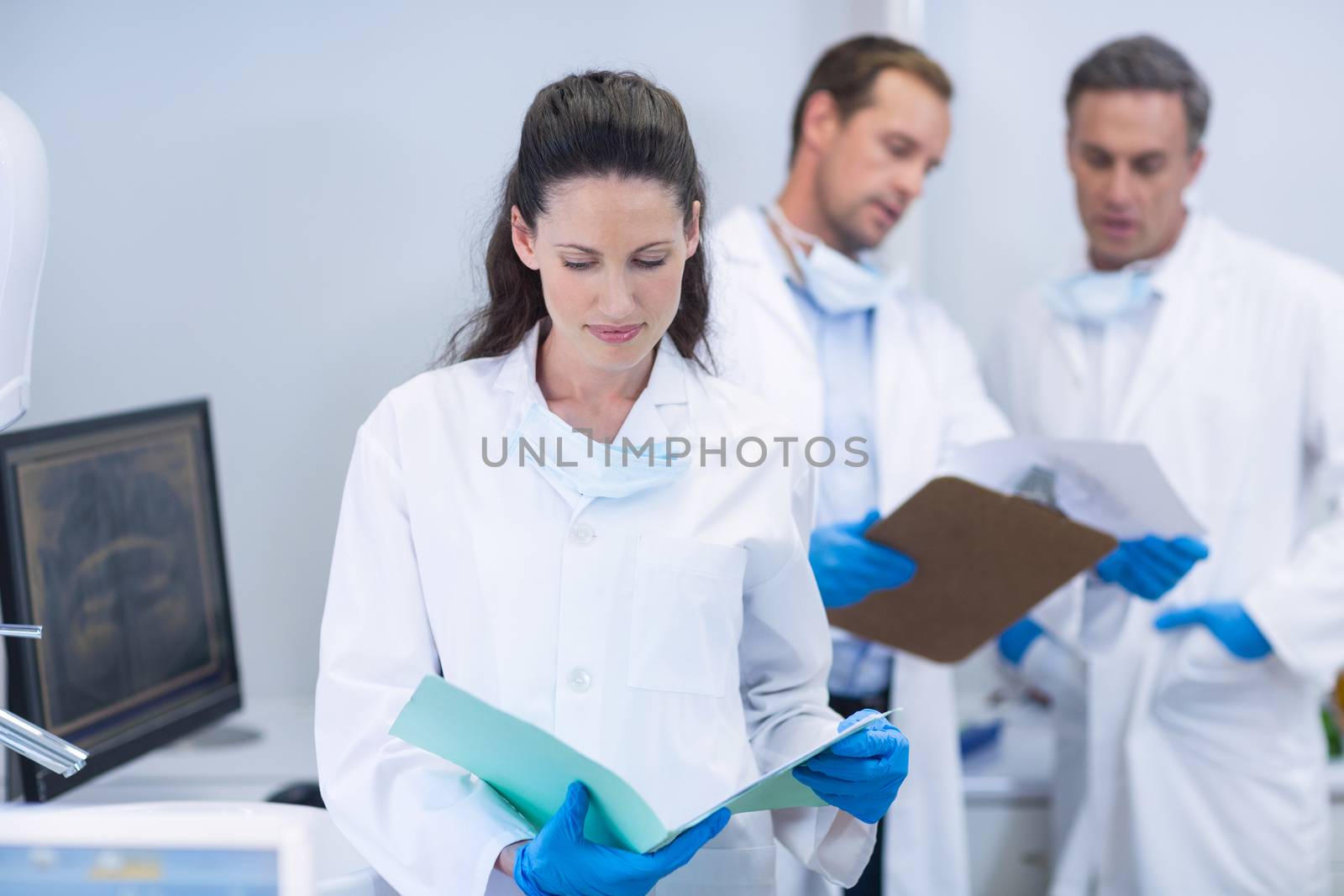 Attentive dentist looking at reports in dental clinic