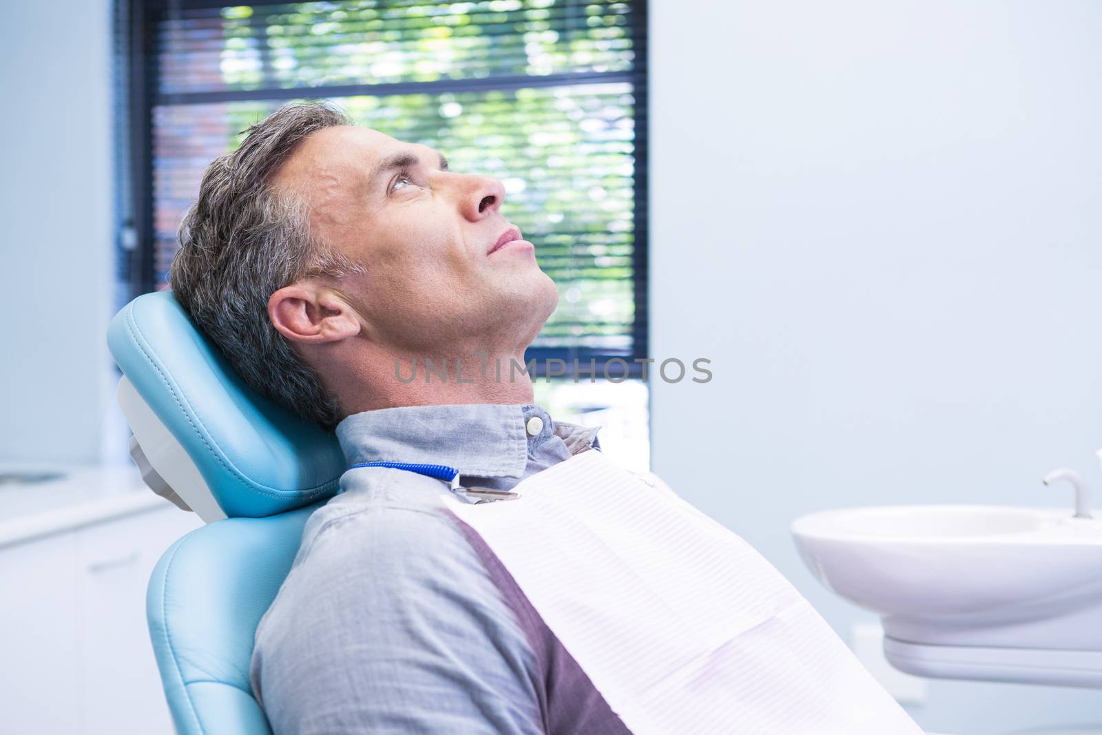 Patient sitting on dentist chair at medical clinic