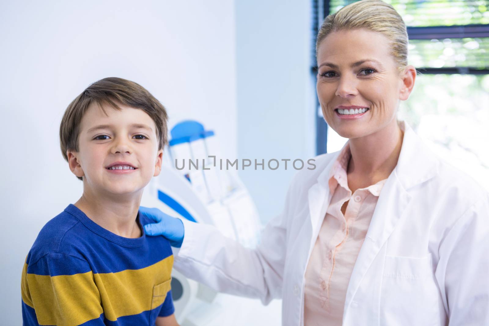 Portrait of happy dentist with boy at medical clinic