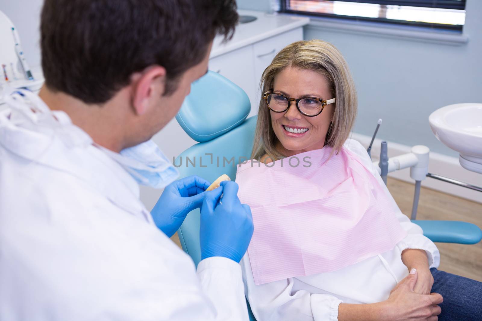 High angle view of patient talking with dentist at medical clinic