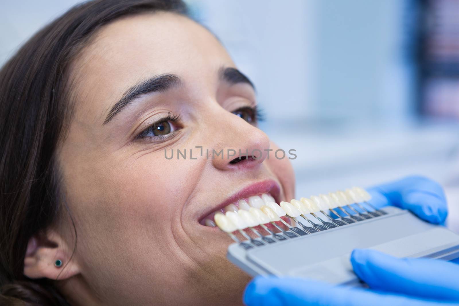 Close up of dentist holding equipment while examining woman at medical clinic