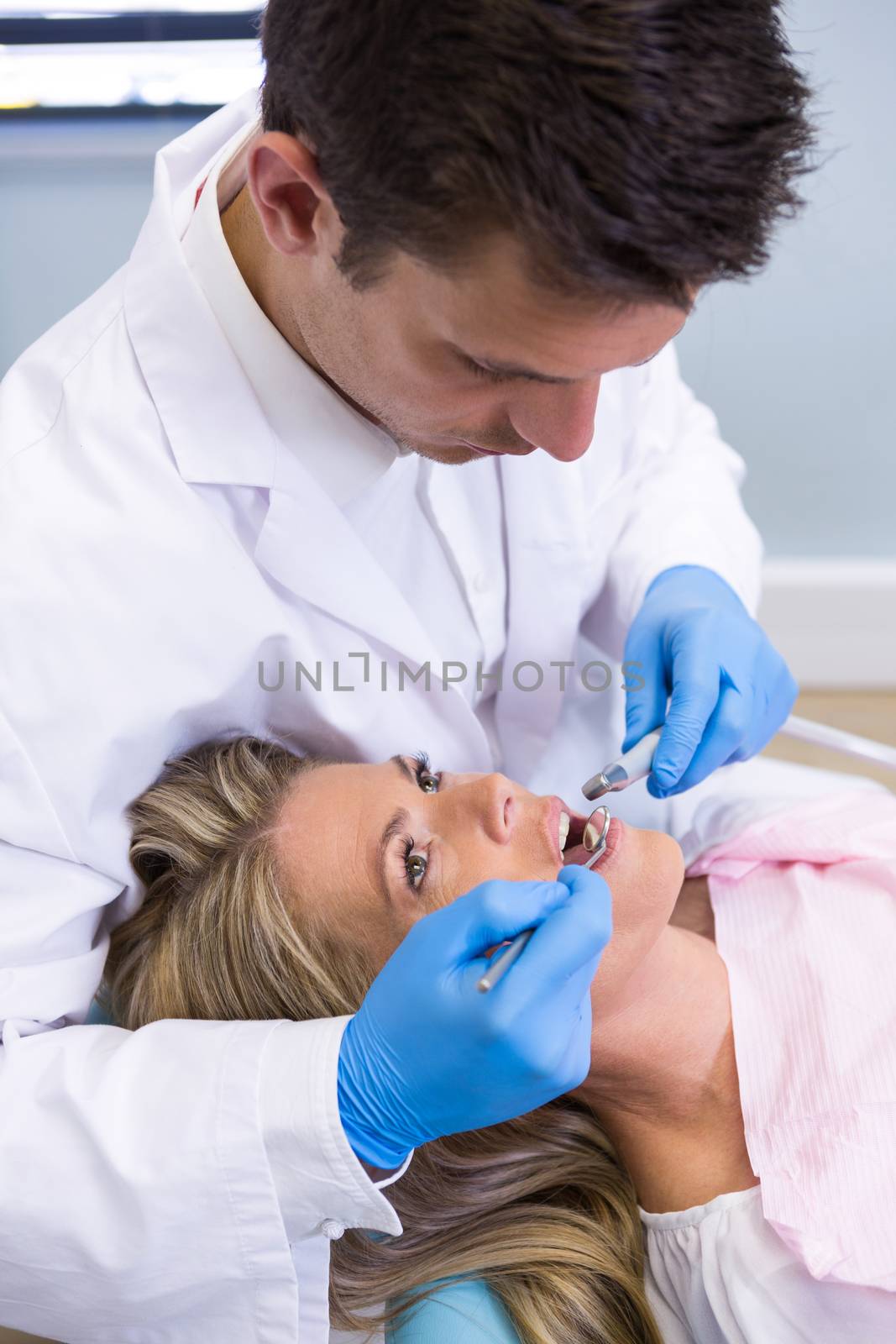Dentist examining patient at medical clinic by Wavebreakmedia